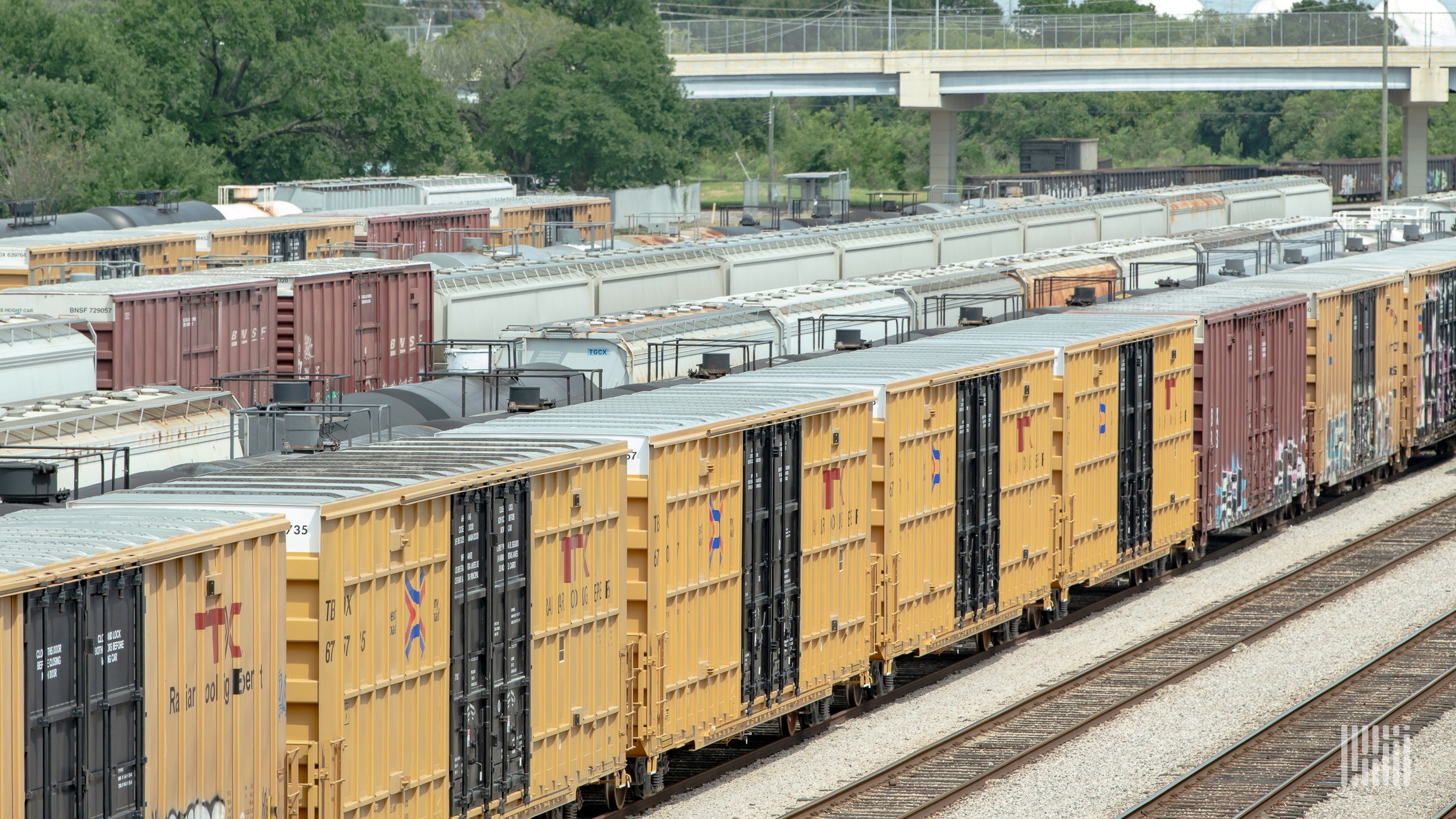 A photograph of a rail cars parked in a rail yard.