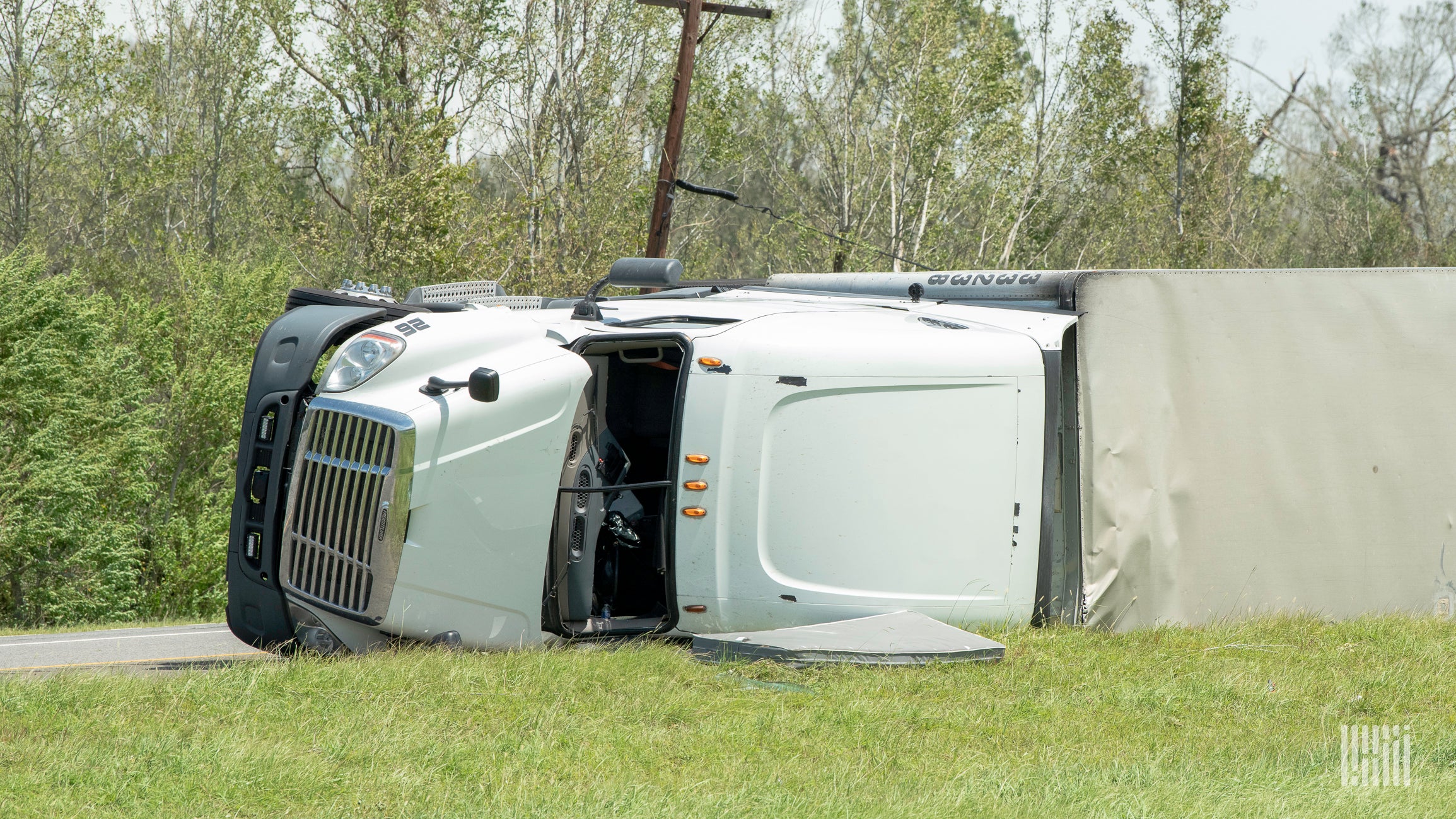 Tractor-trailer tipped over on side of a road.