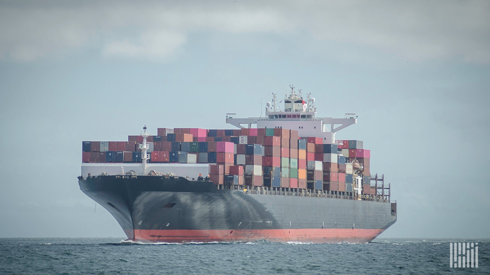 A container ship travels on the water to illustrate an article about cybercriminals selling access to shipping firms