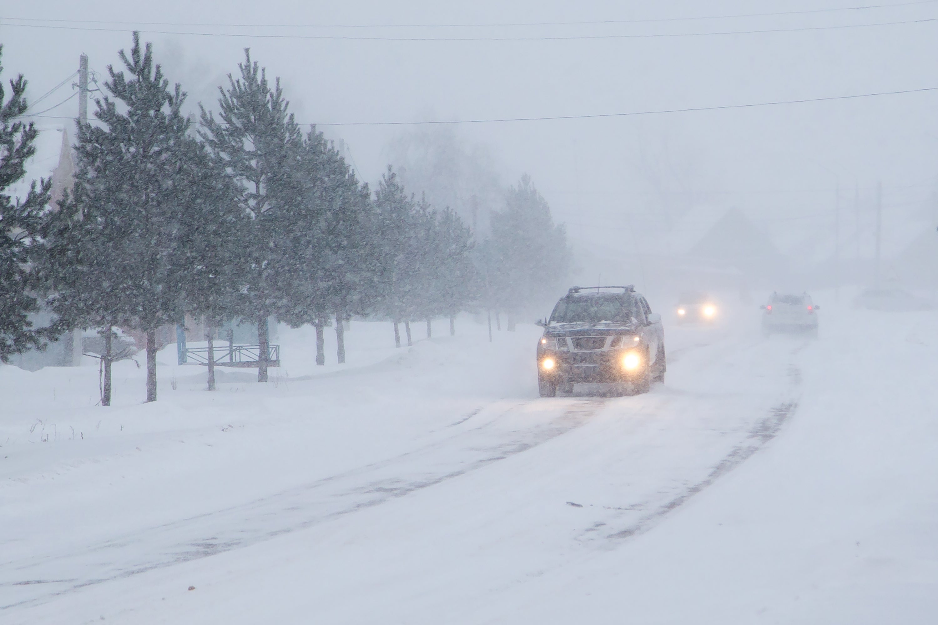 Cars driving through a blizzard.