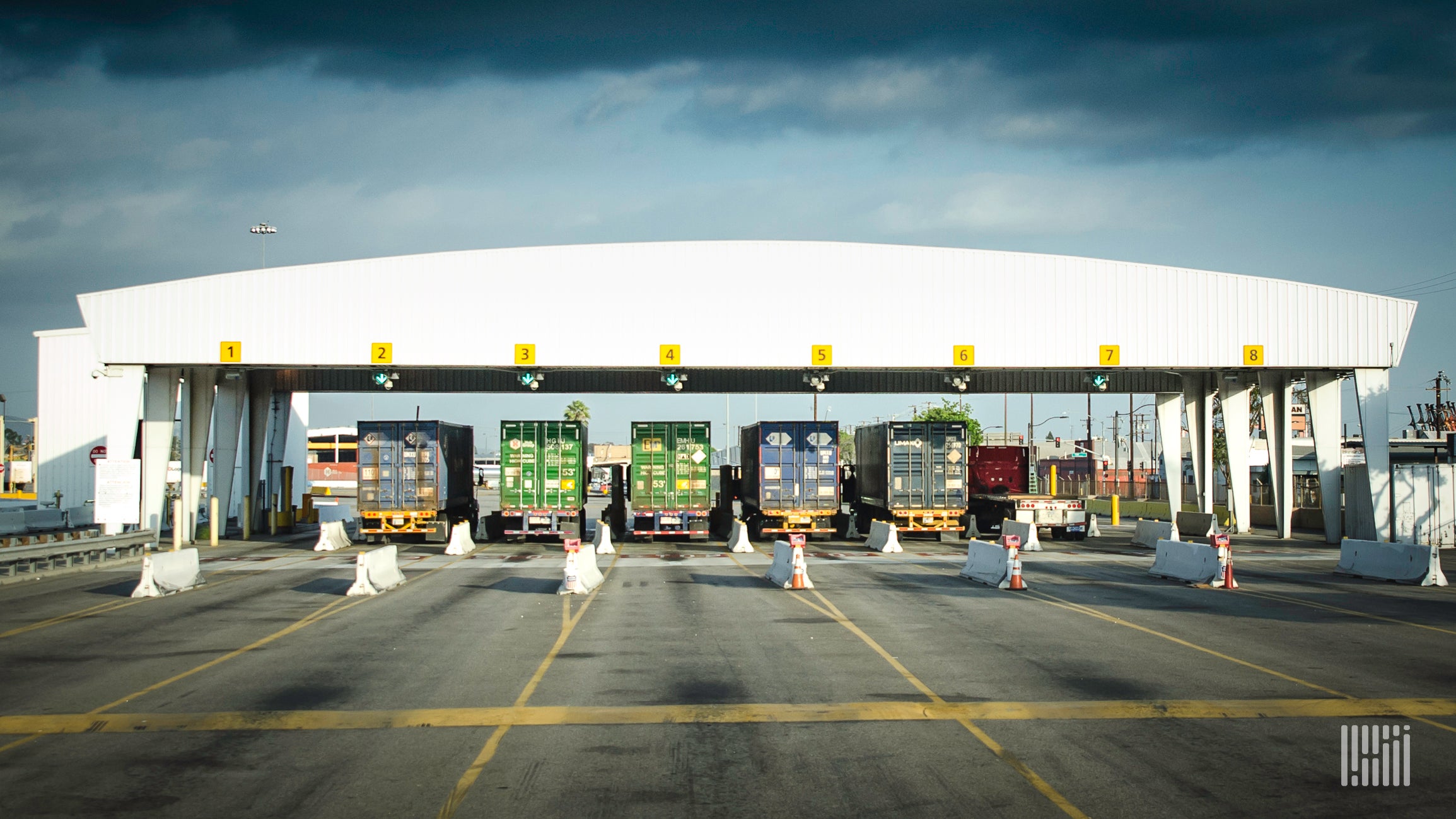 A photograph of trucks hauling intermodal containers out of terminal gate.