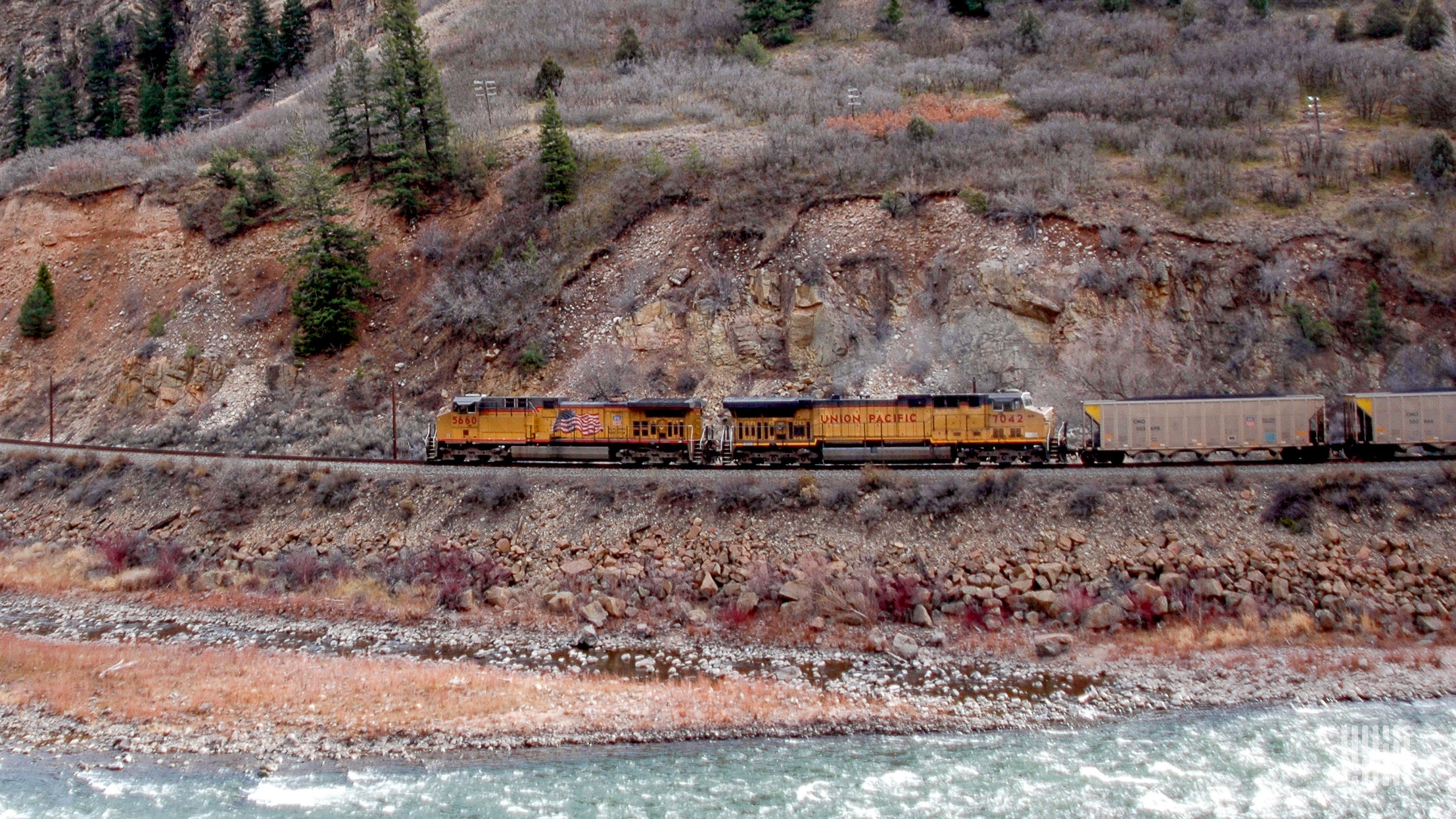 A photograph of a Union Pacific train hauling coal over a mountainous landscape.