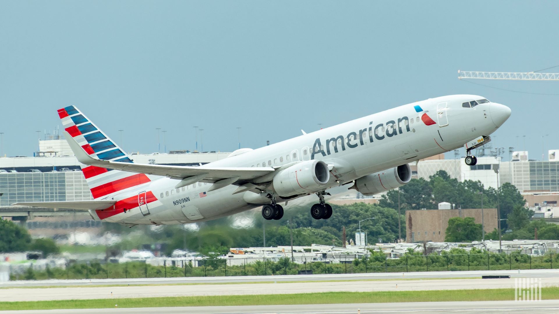 An American Airlines jet lifts off from runway.