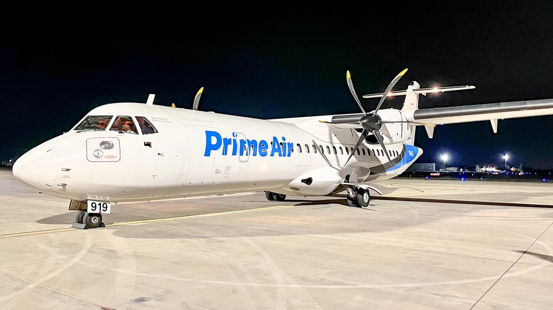 A white propeller plane with Prime Air lettering in light blue.