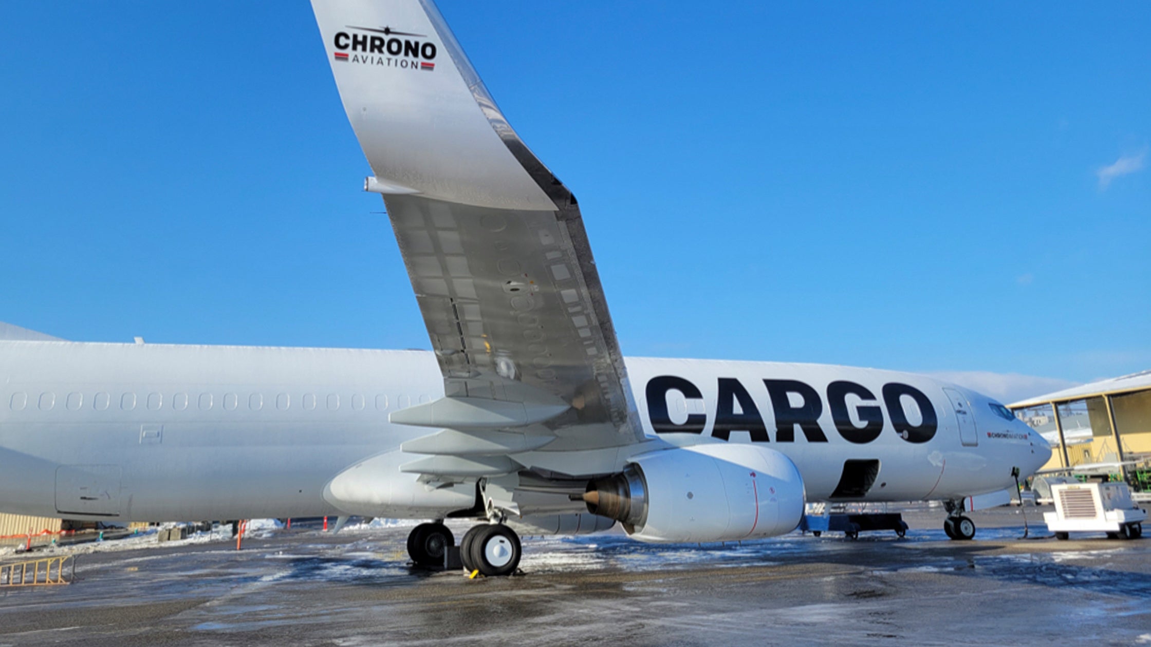 A side view close up a white cargo jet with Chrono Aviation logo.