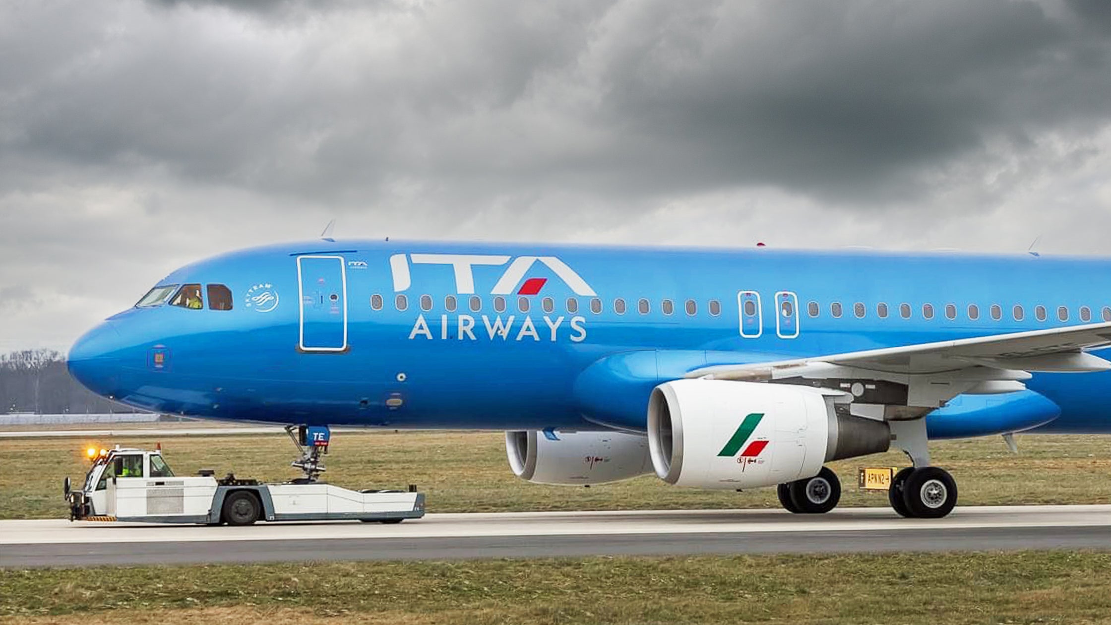 A side view of bright blue ITA Airways aircraft.