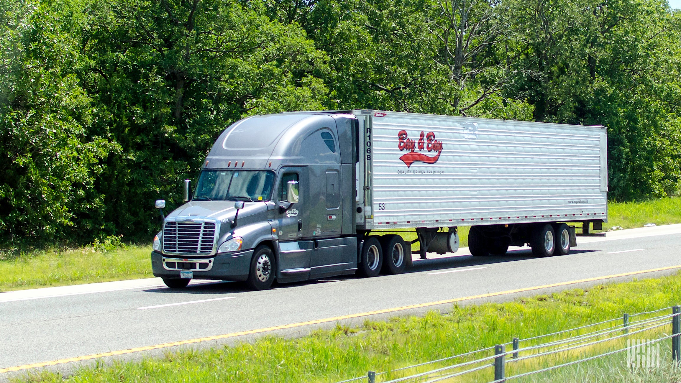 A tractor-trailer of Minnesota trucking company Bay & Bay traveling on a highway.