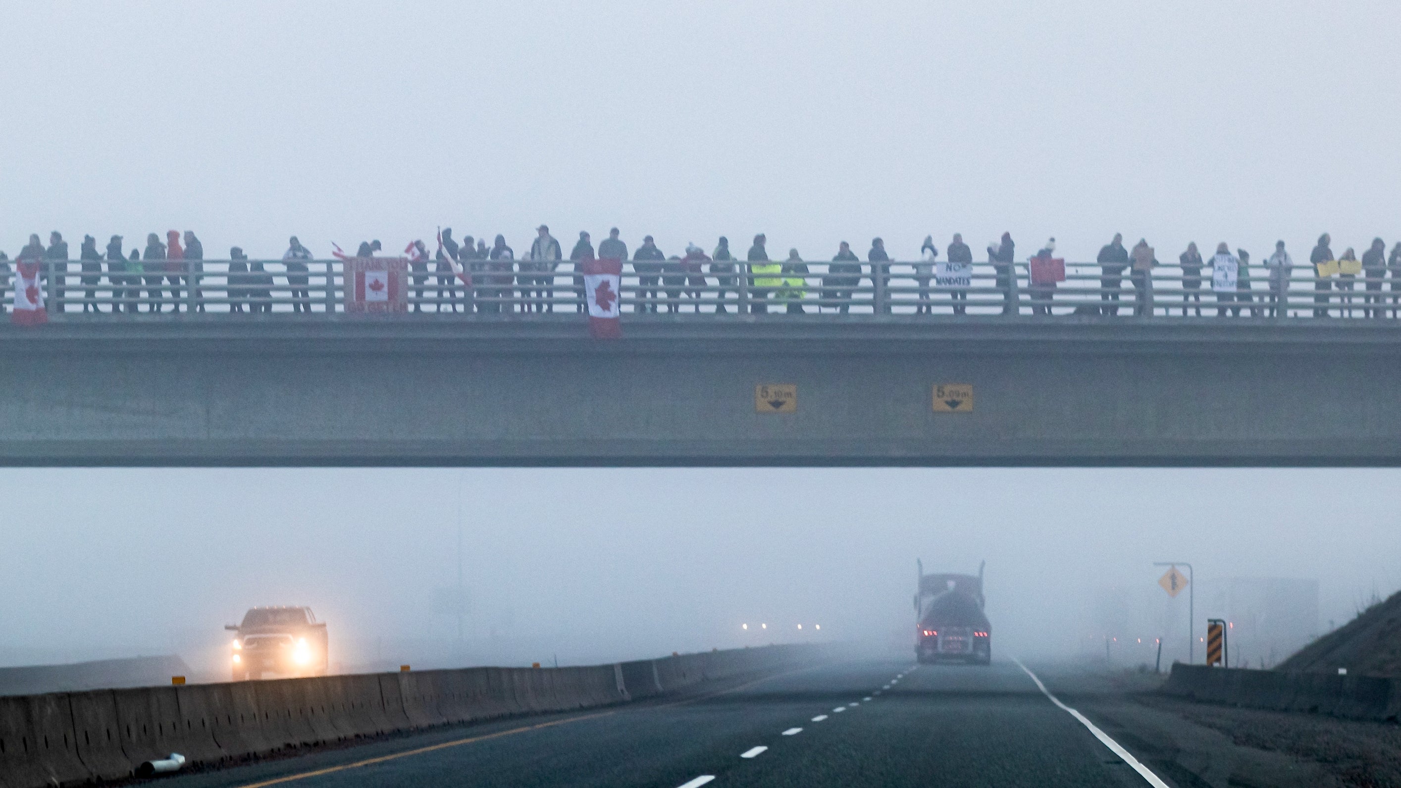 Protesters gather on overpasses on Highway 1 to protest the coronavirus vaccine mandate for commercial transportation truck drivers