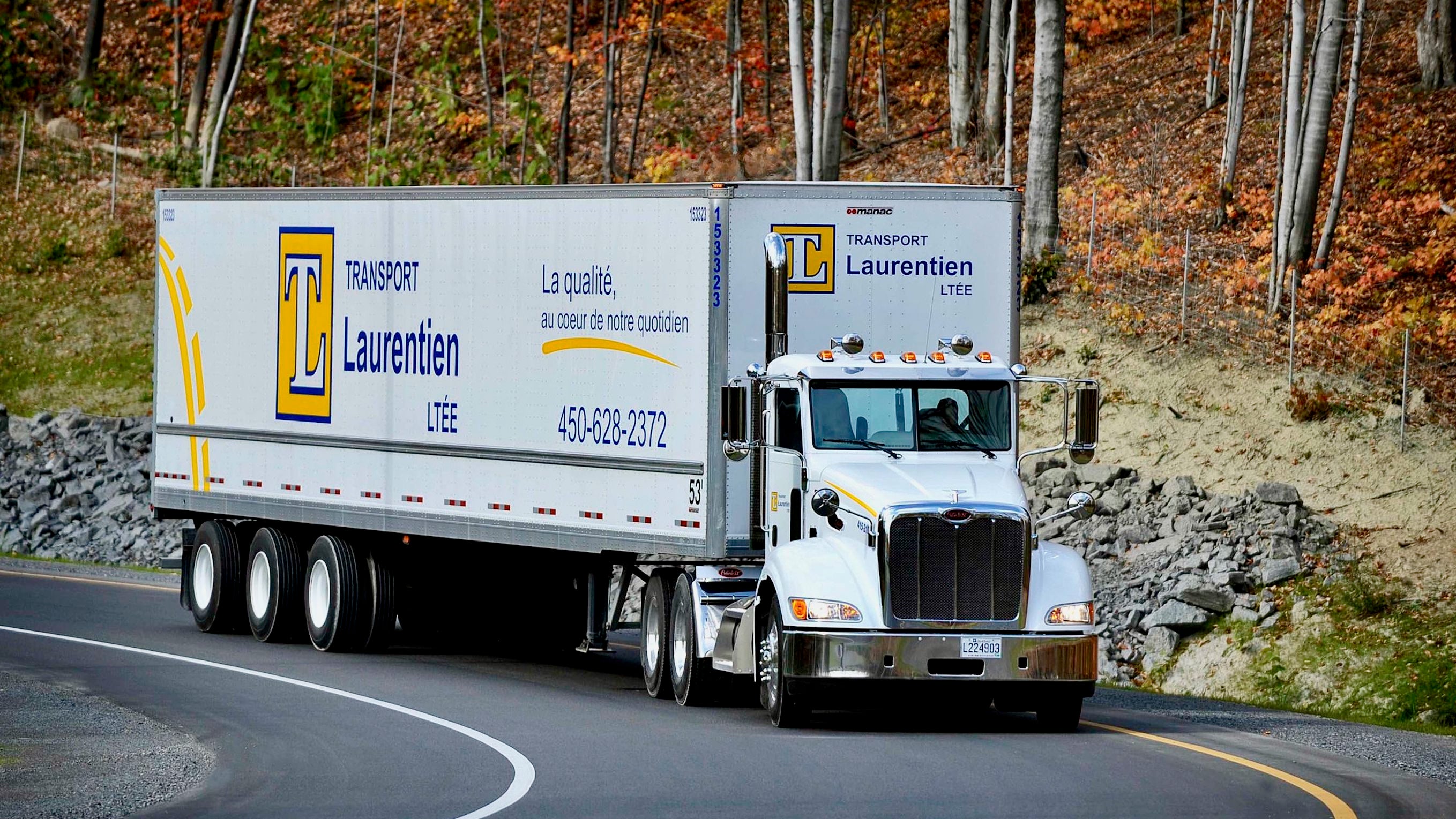 A white tractor-trailer of trucking company Laurentien Transportation, which was acquired by Canada Cartage, seen from the front on a road.