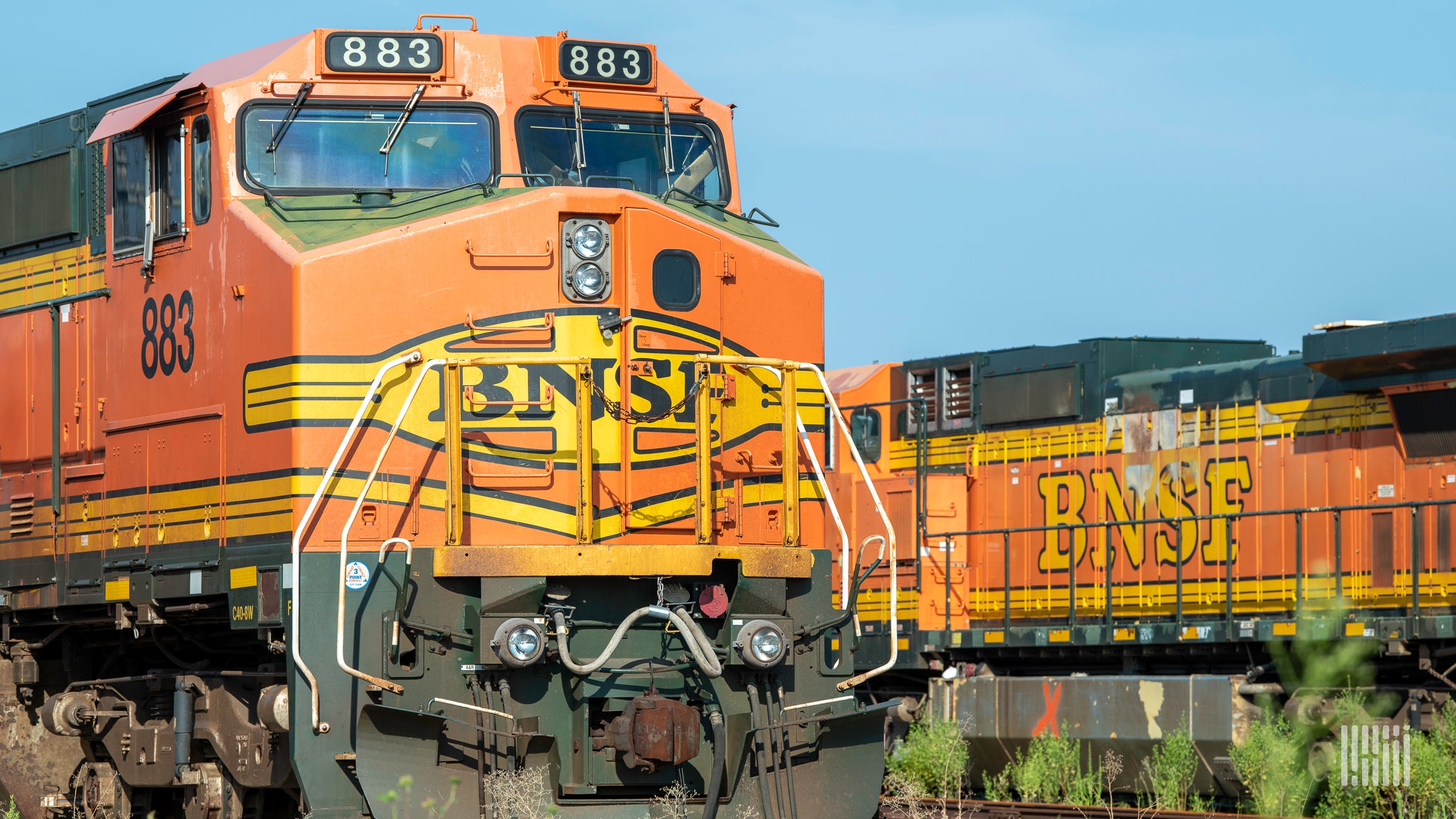 A photograph of two BNSF locomotives parked in a rail yard.