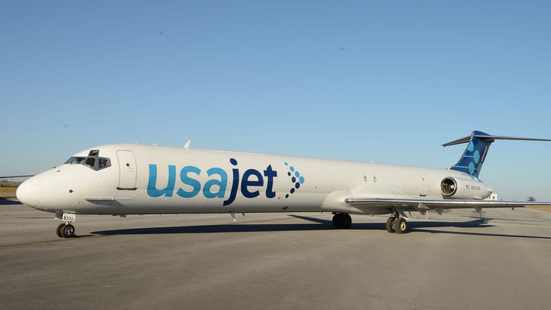 A white USA Jet cargo jet with twin-engines on the tail.