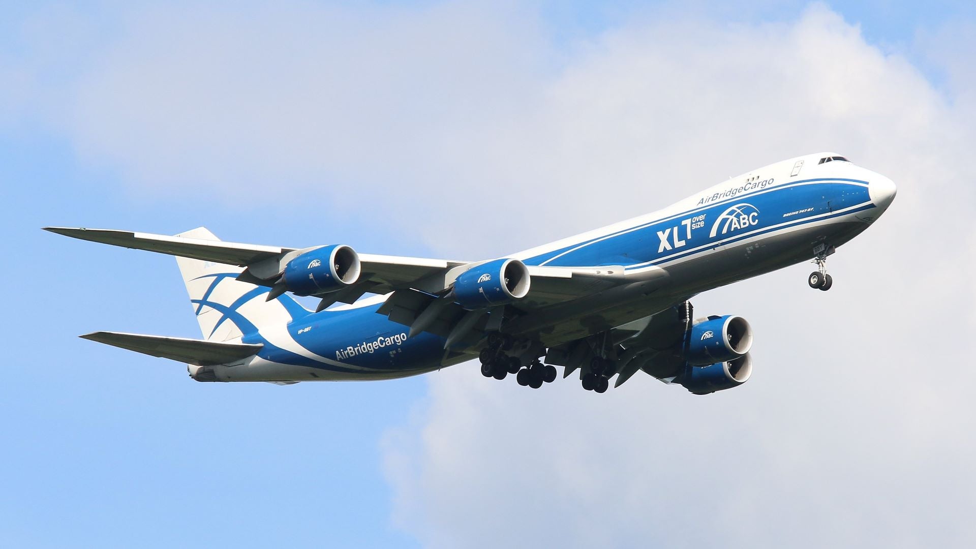 A white and Blue 747 jumbo jet on approach for landing.