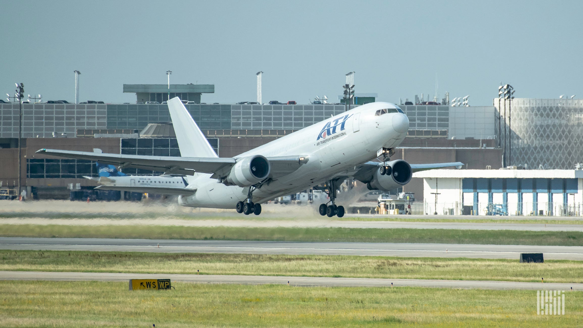 A white Air Transport International plane touches down on runway.