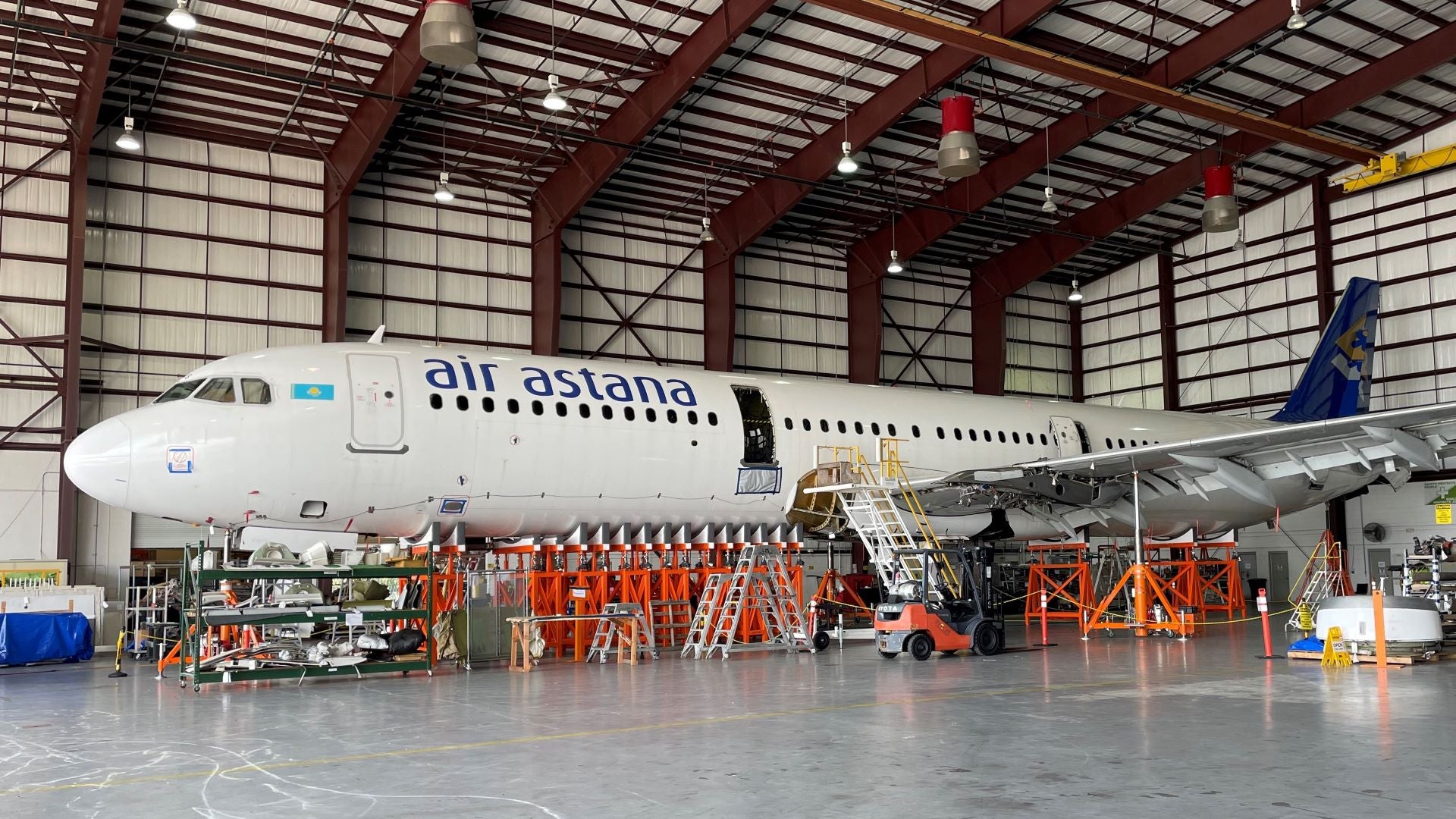 A plane on struts in maintenance hanger.