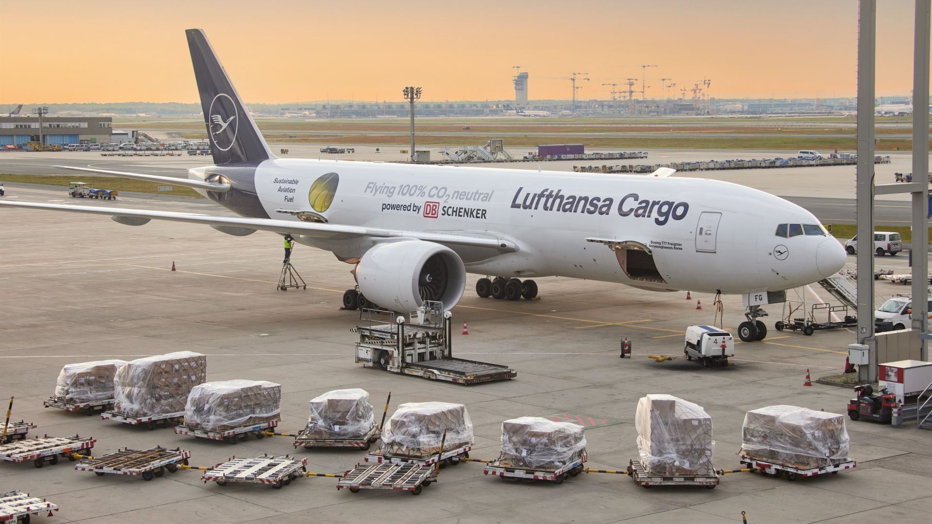 A Lufthansa Cargo jet with containers waiting on the tarmac for loading.