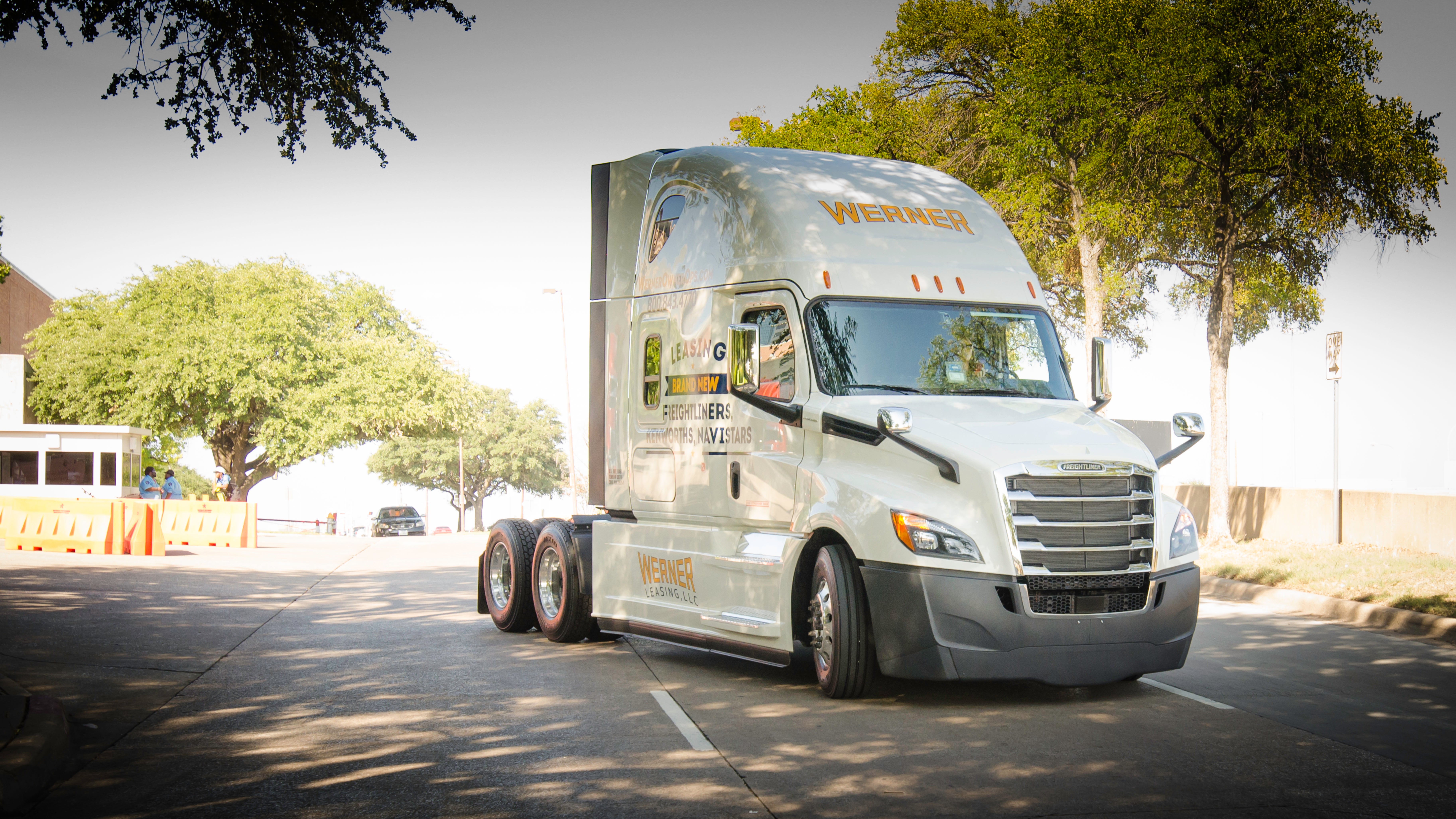 A white semi truck of Werner Enterprises on a city srteet.