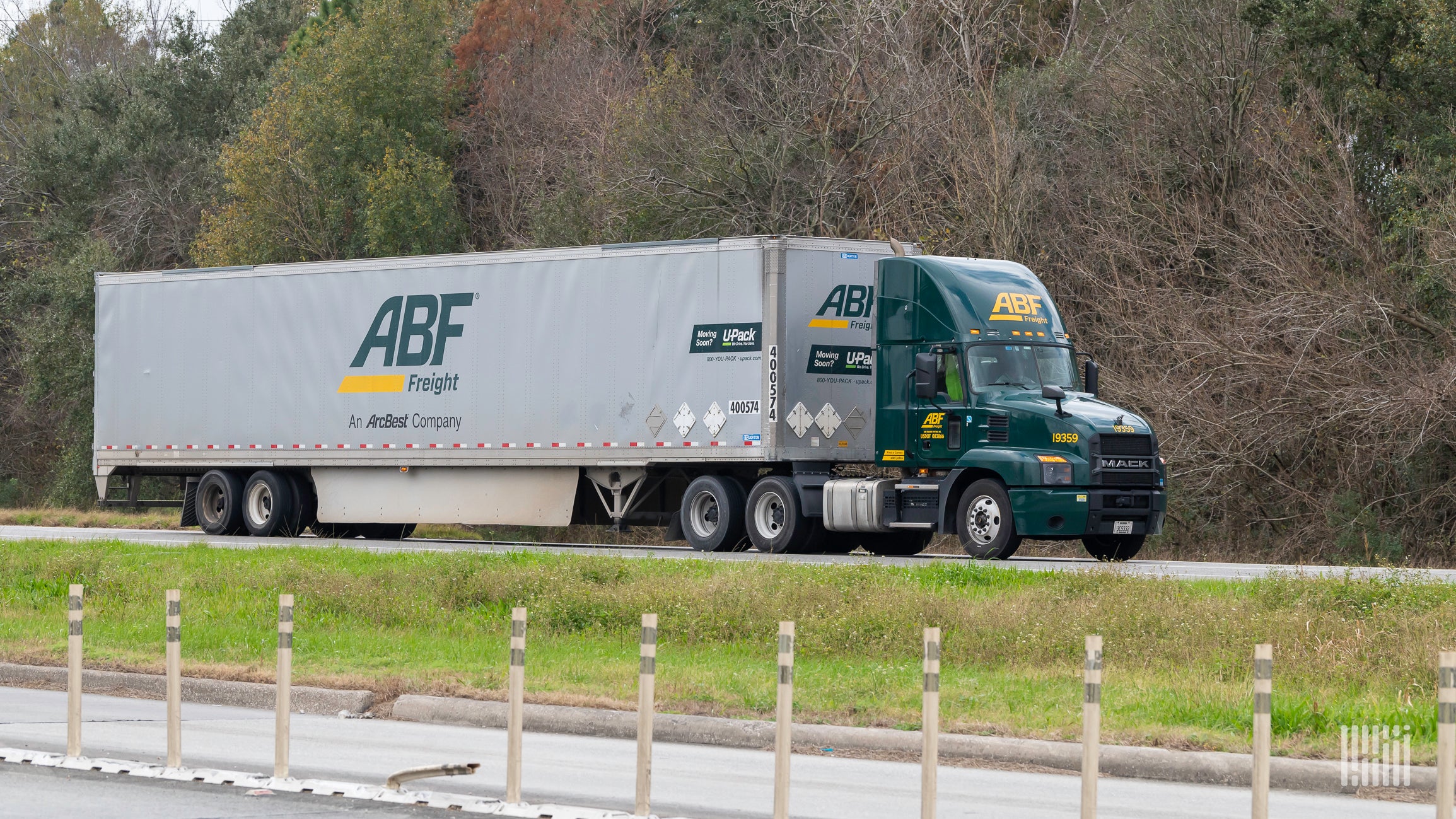 Green ABF truck and gray trailer on highway