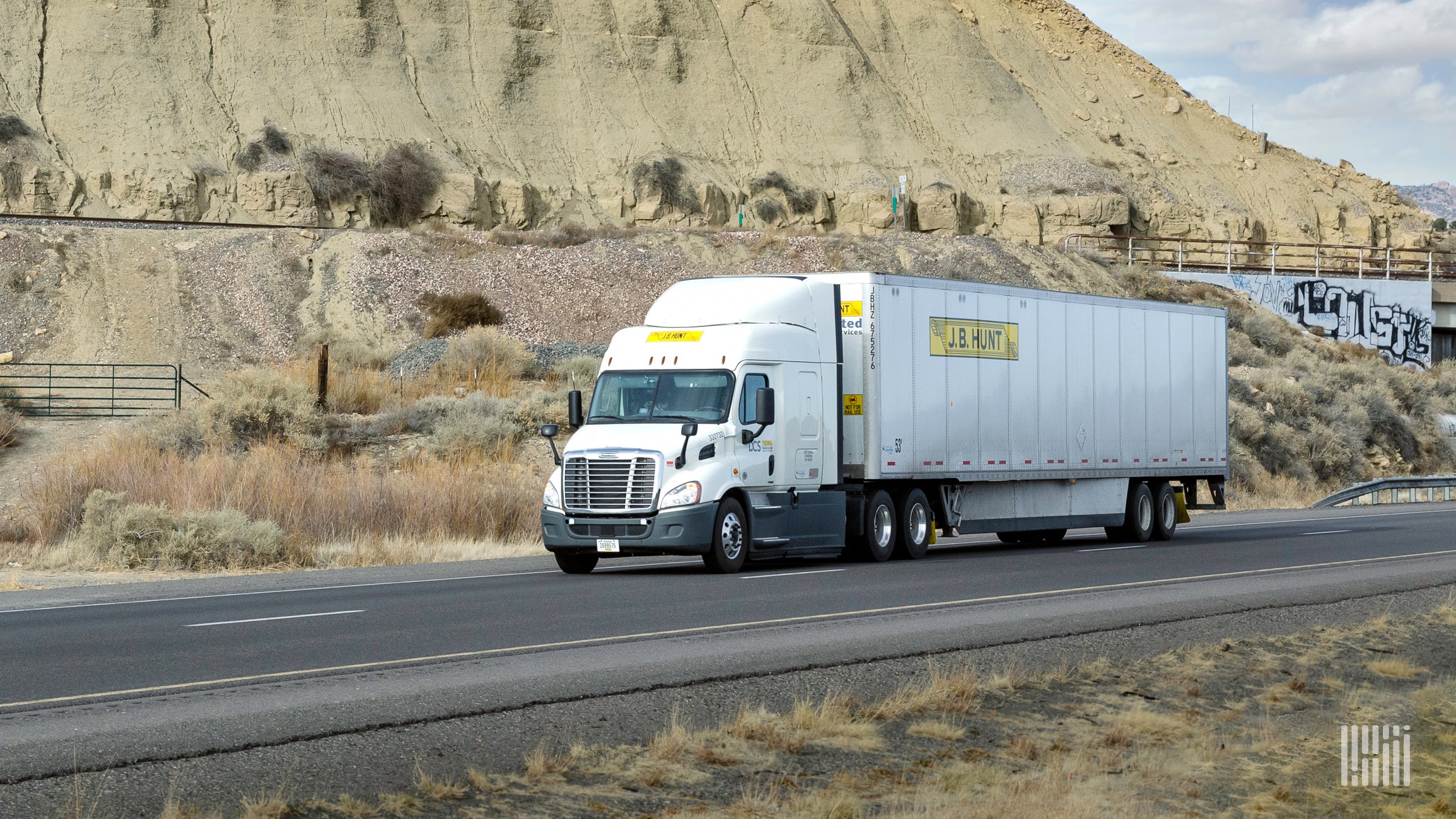 A white J.B. Hunt tractor-trailer on highway