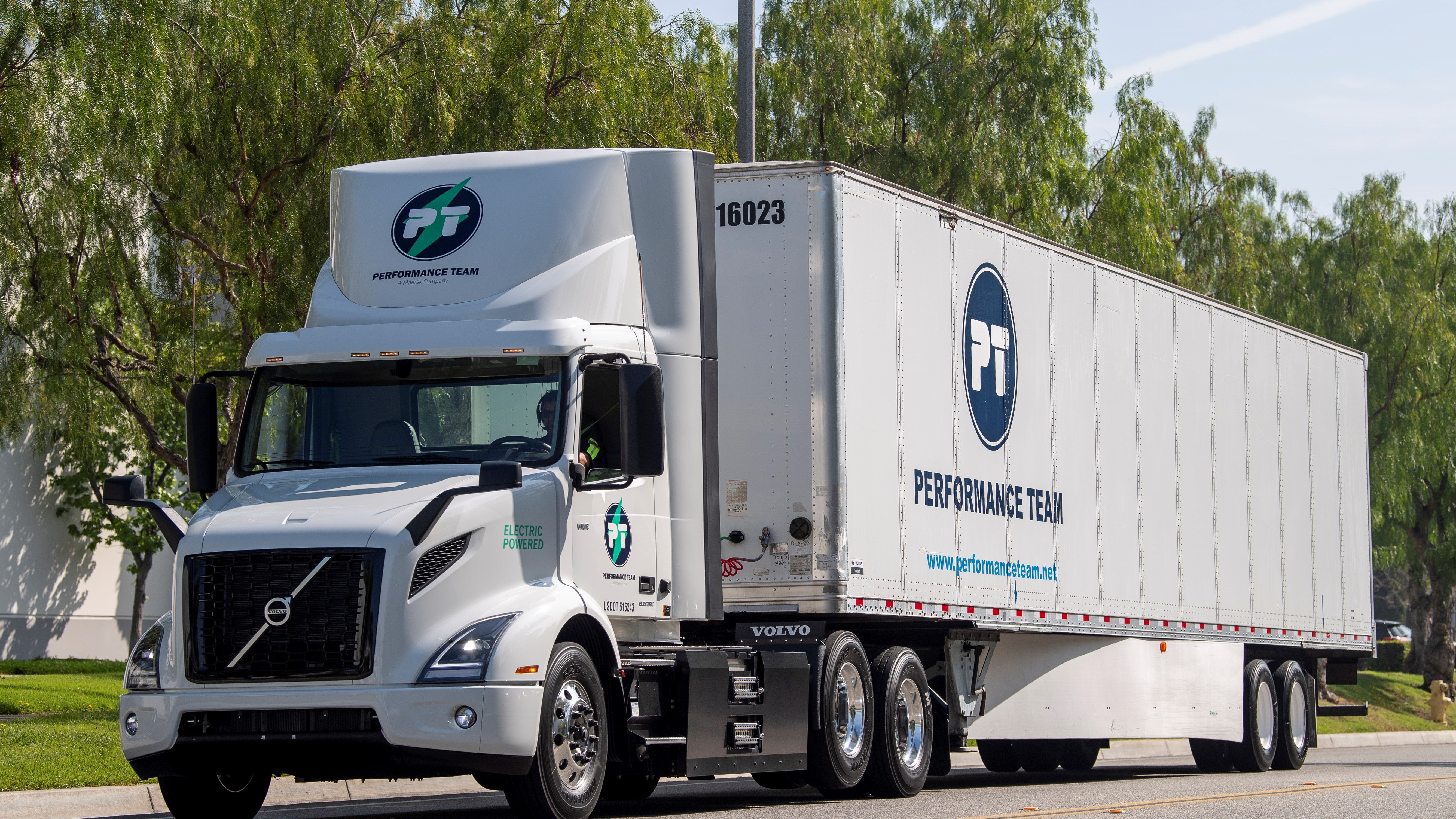 A white Volvo VNR Electric hauling Maersk Performance Team trailer