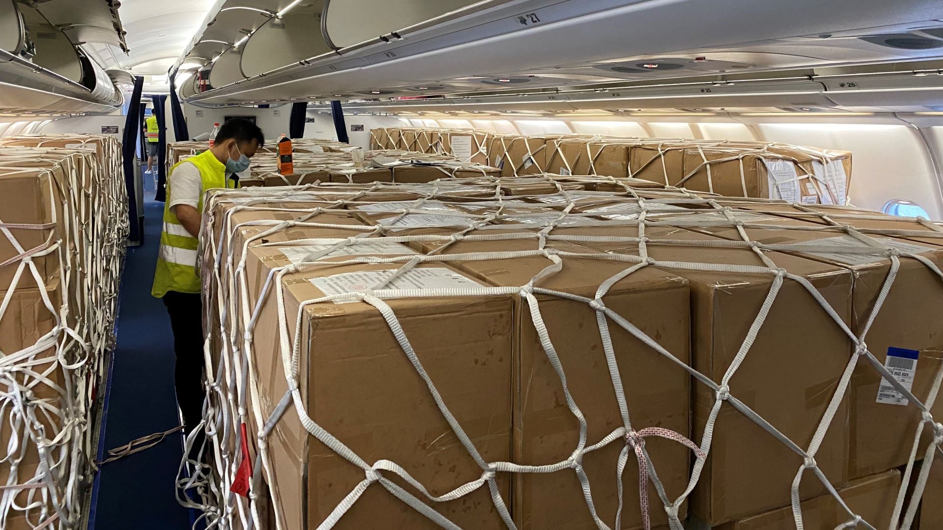 Boxes of cargo tied down with netting in the passenger compartment of an aircraft. The EU is ending permission for such loading.