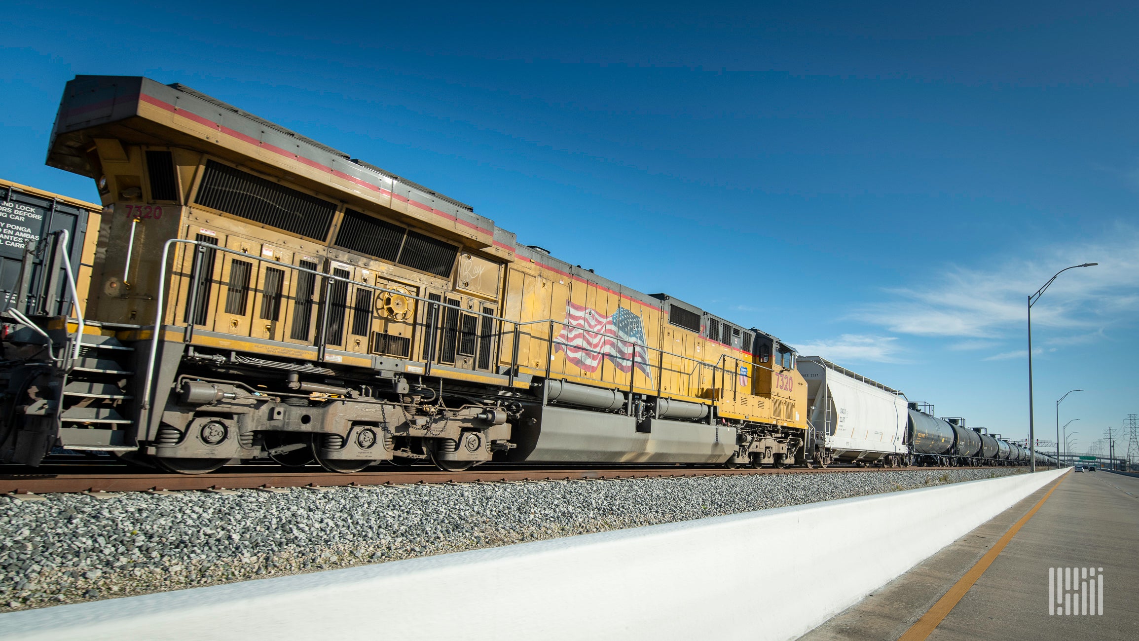 A Union Pacific locomotive hauls a hopper car and tank cars.