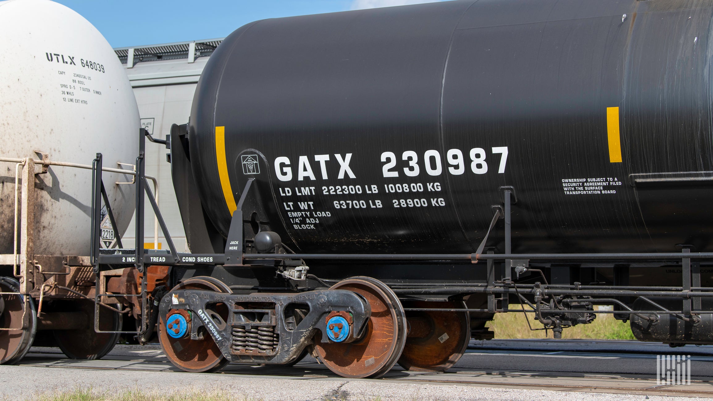 A photograph of a GATX tank car next to other tank cars in a rail yard,