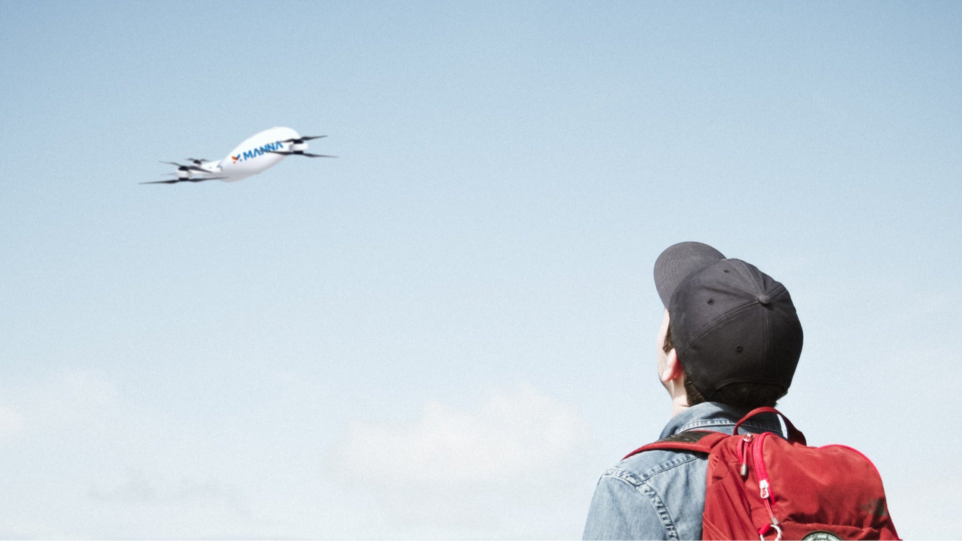 A Manna delivery drone flies over a waiting customer