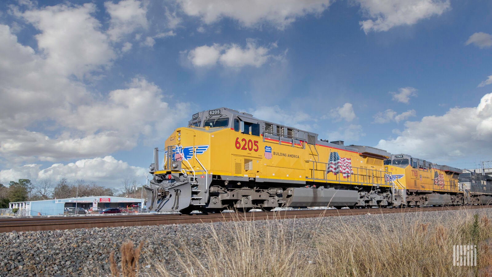 Yellow Union Pacific train traveling through a field.