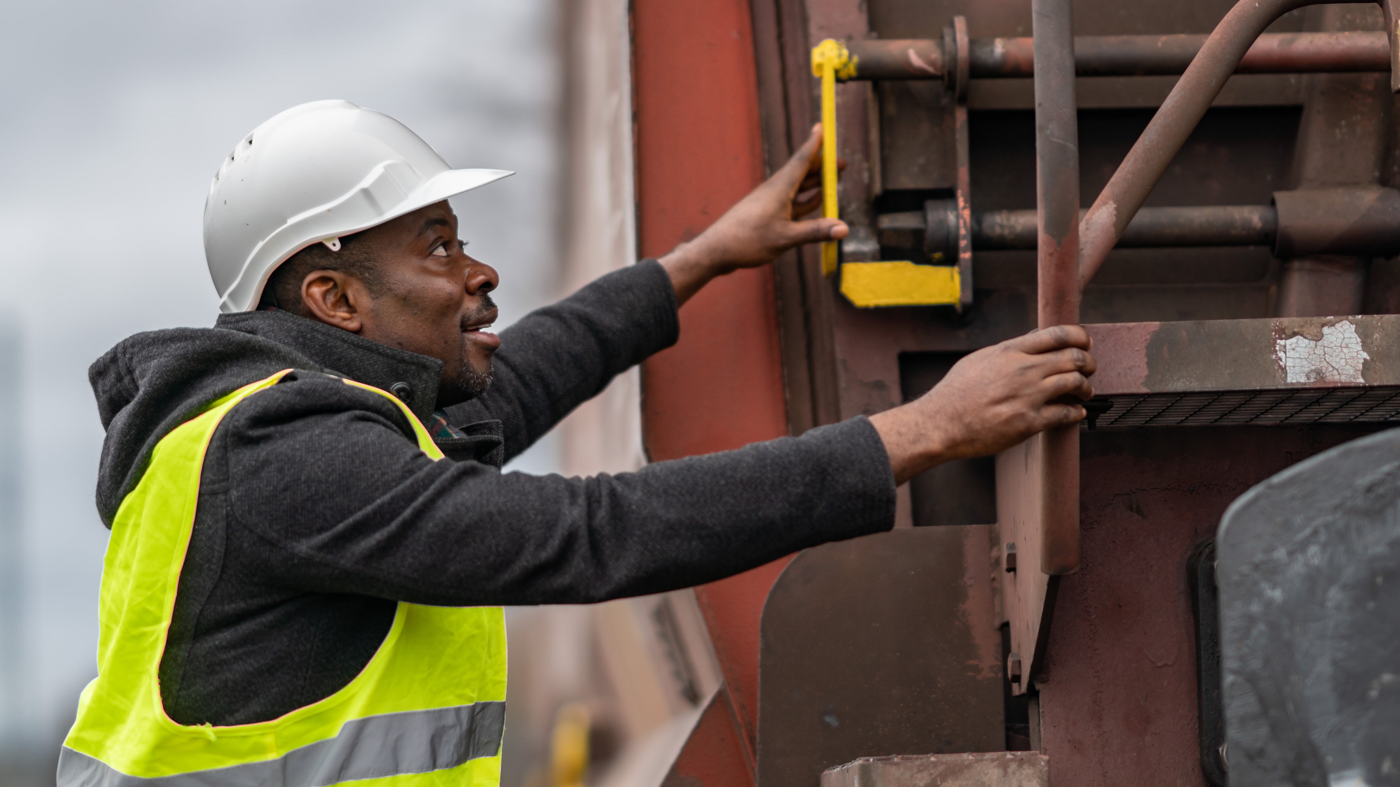 A photograph of a man preparing to climb onto a train.