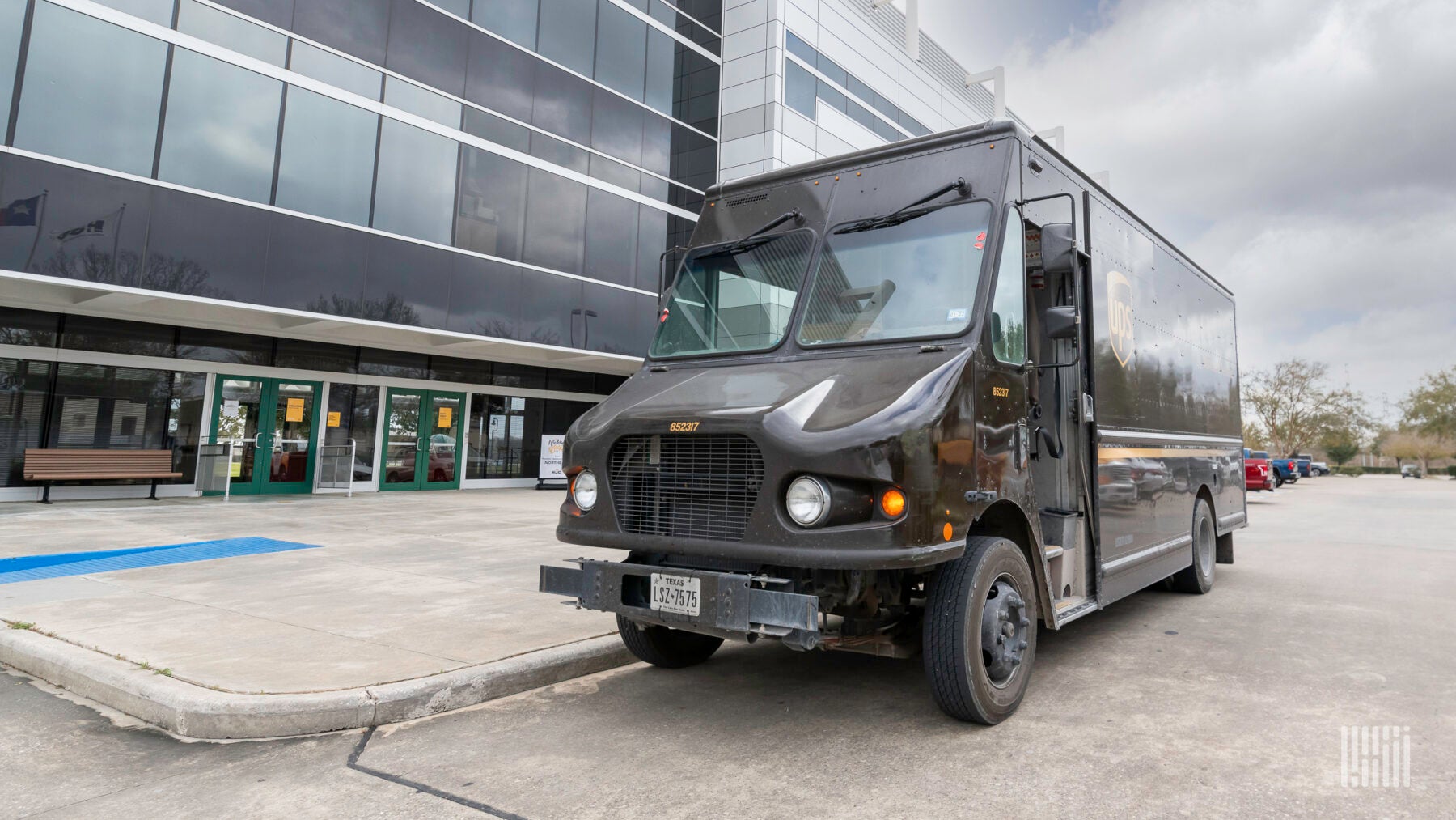 A brown UPS delivery van parked outside a building