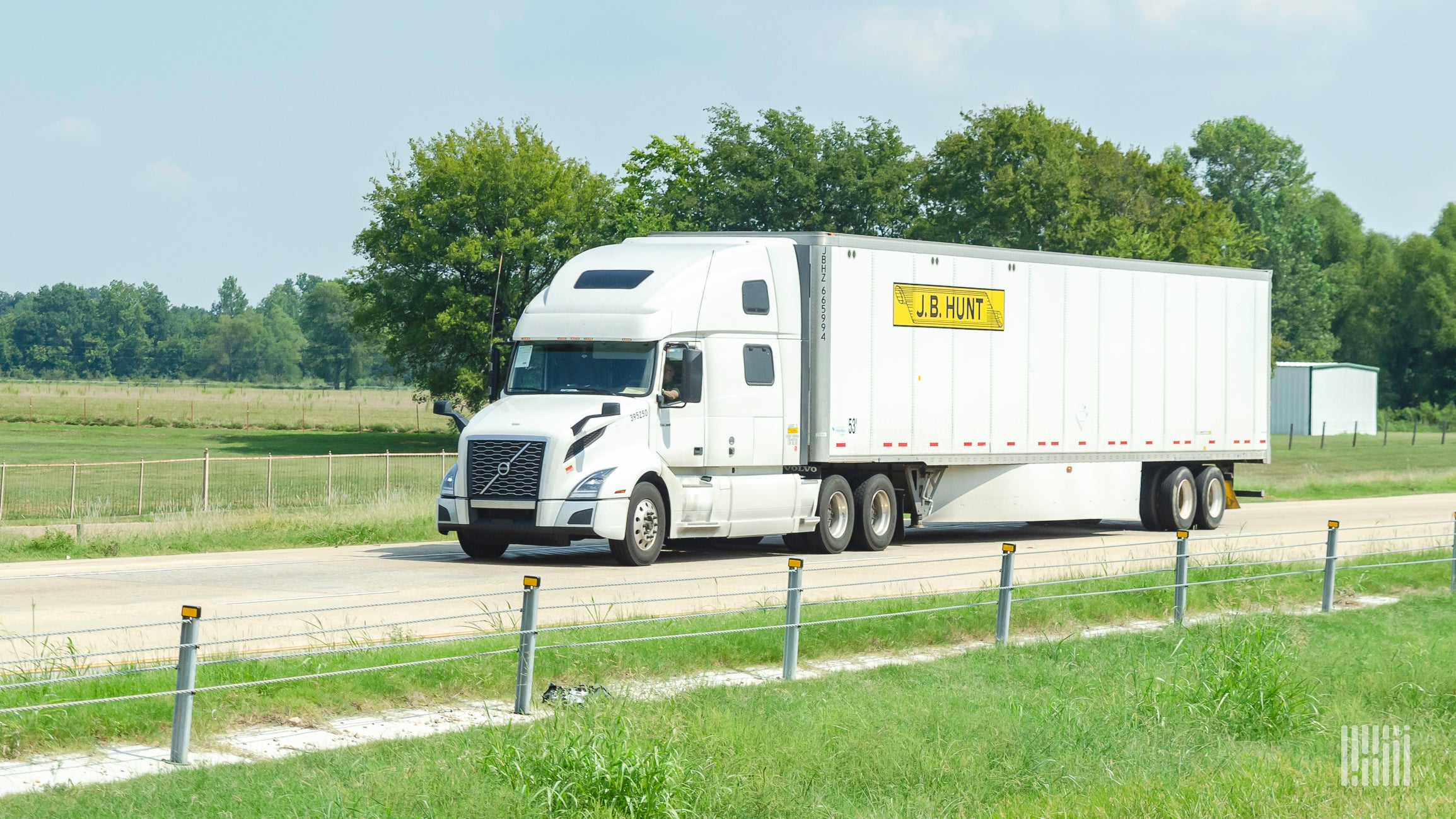 A white J.B. Hunt tractor pulling a white J.B. Hunt trailer