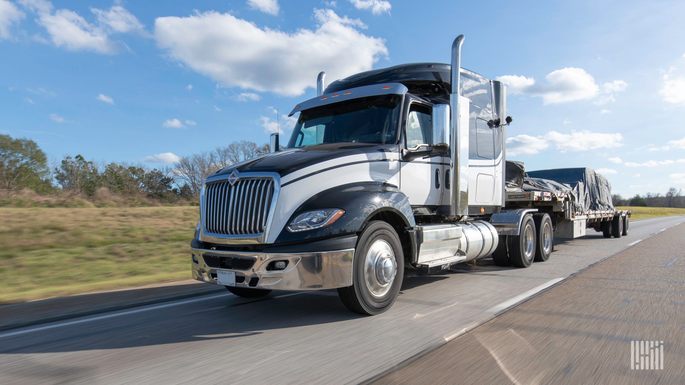 A tractor hauling a covered flatbed trailer