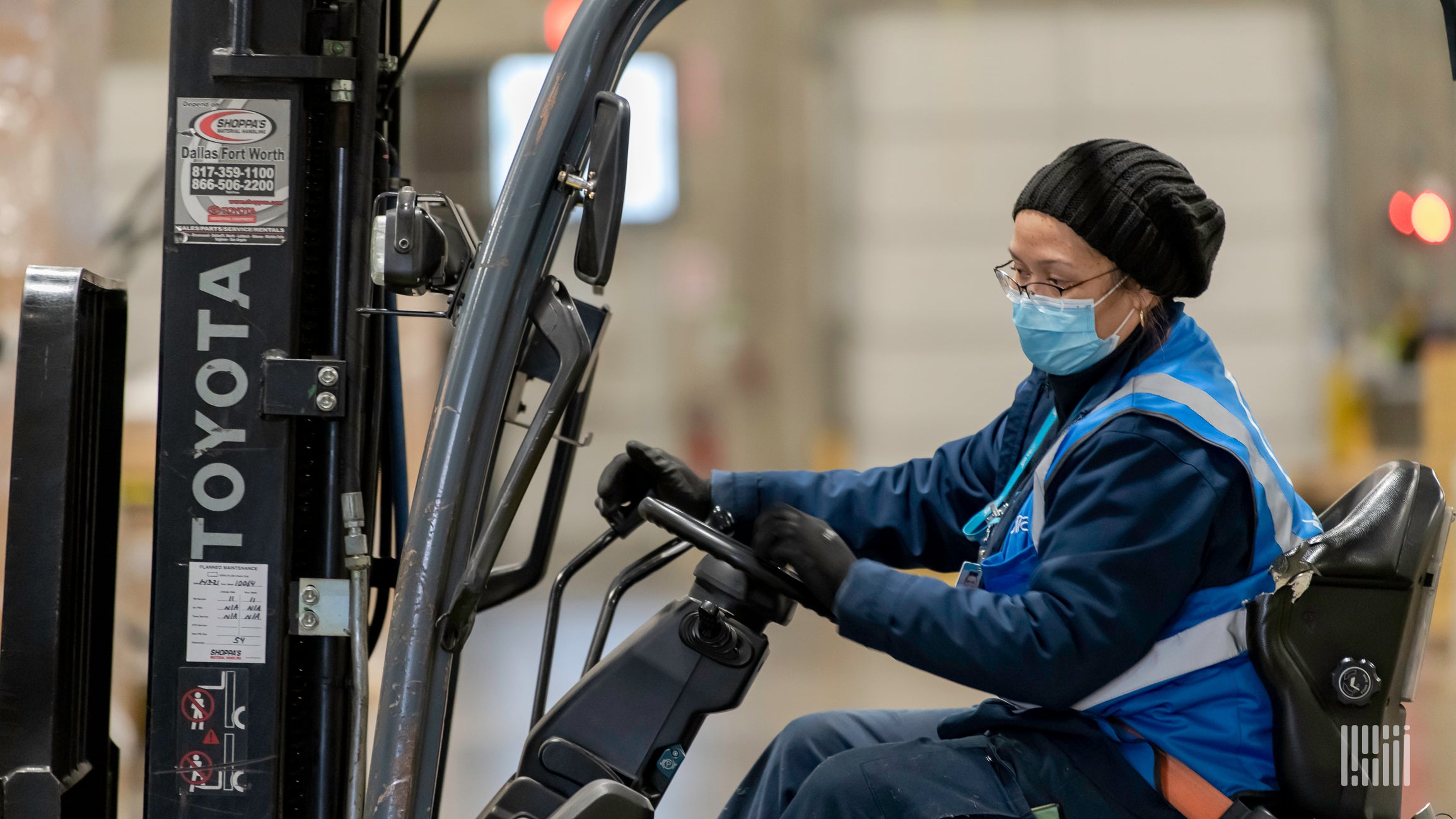 Woman driving forklift in warehouse