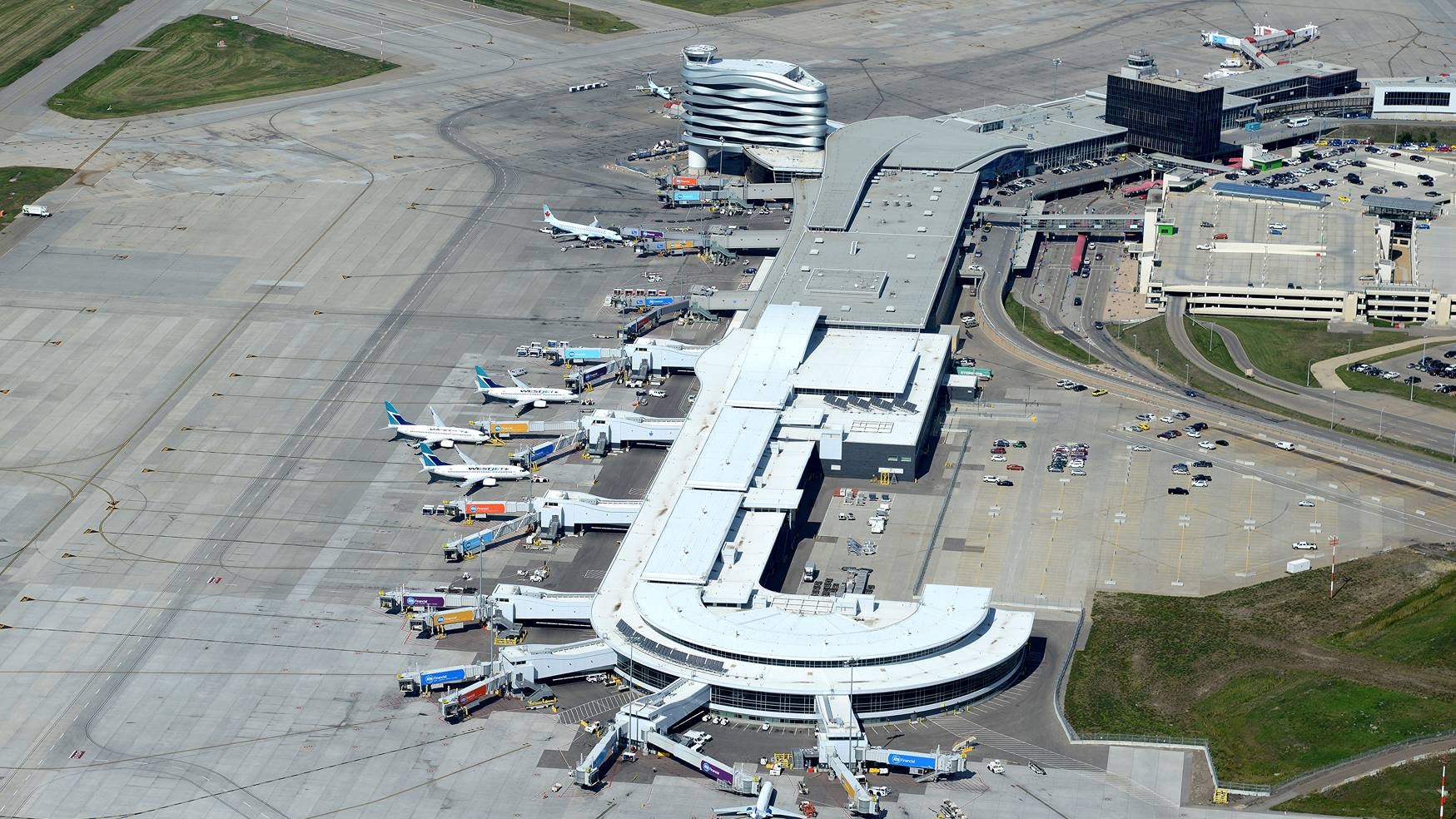 A birds eye view of a terminal at the Edmonton International Airport shows several airplanes surrounding the building.