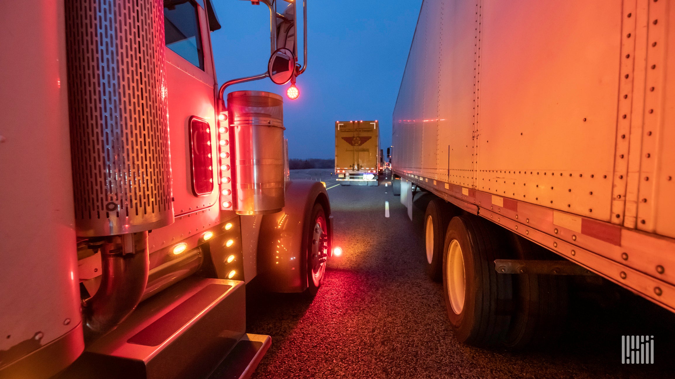 A view between trucks on a road.