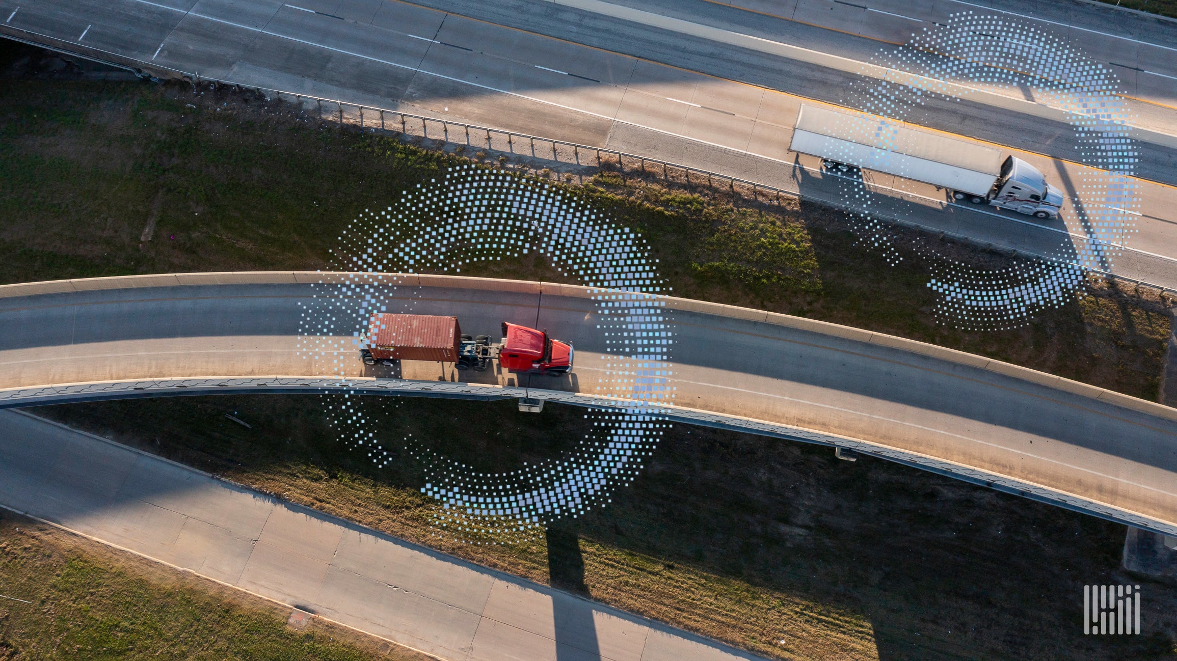 An aerial view of roads shows technology mixed with trucks on the road.