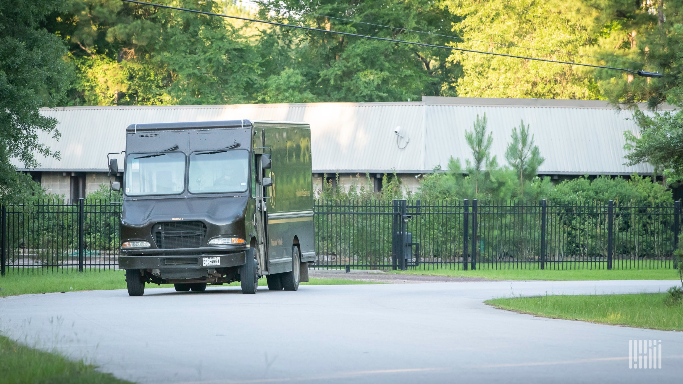 Brown UPS delivery van leaving package facility