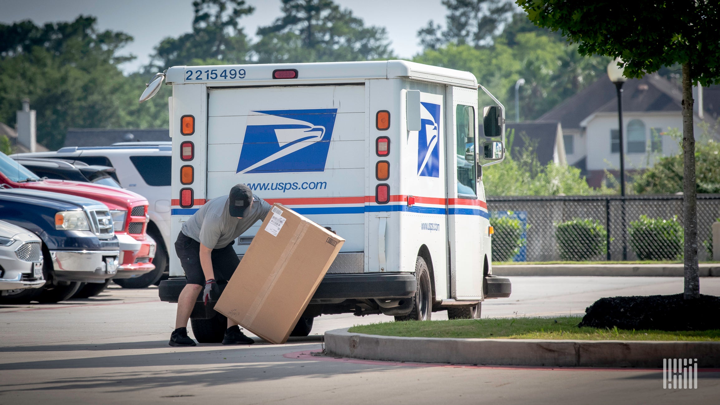 U.S. Postal Service carrier unloads a package from his vehicle