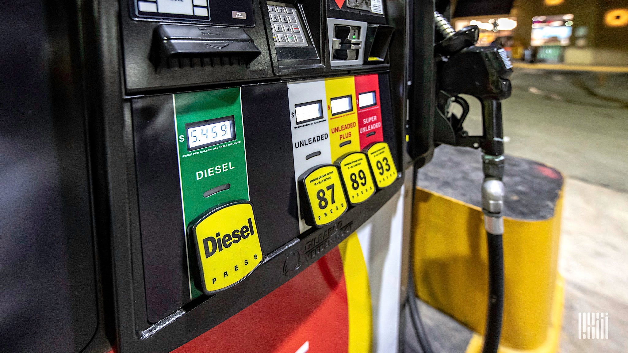 A diesel pump showing the price $5.459 next to regular gas pumps