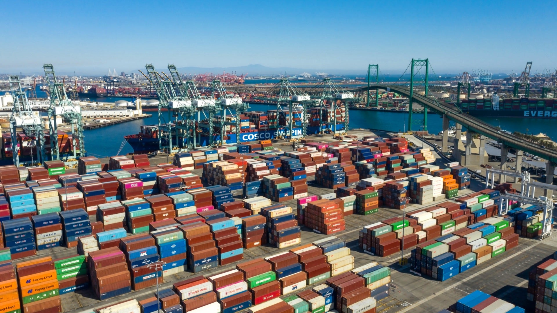 An aerial view of the Port of Long Beach, showing thousands of shipping containers stacked.