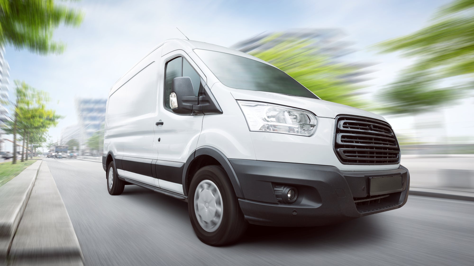 White delivery van speeding through city streets