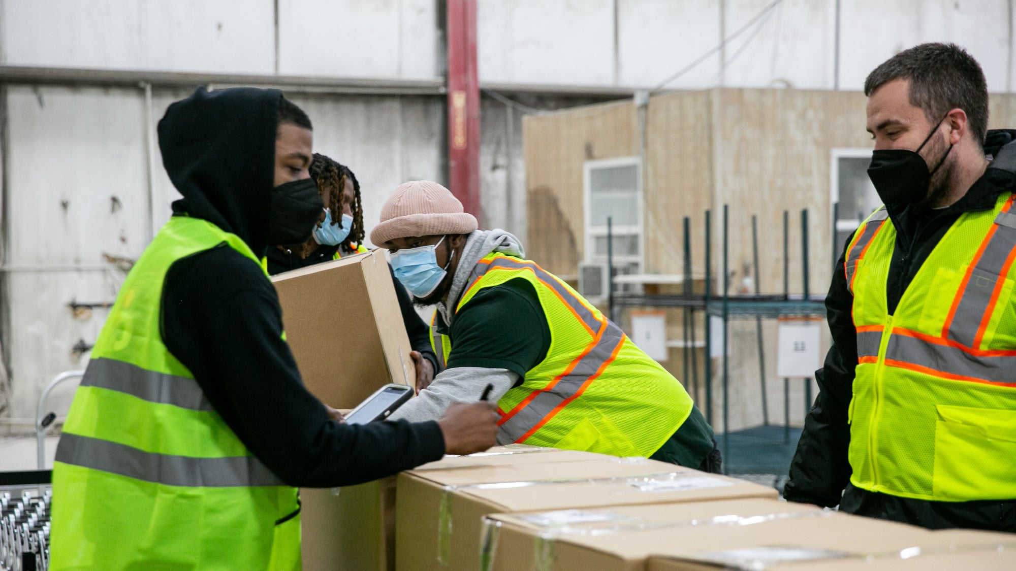 Man lifts ecommerce package off conveyor belt