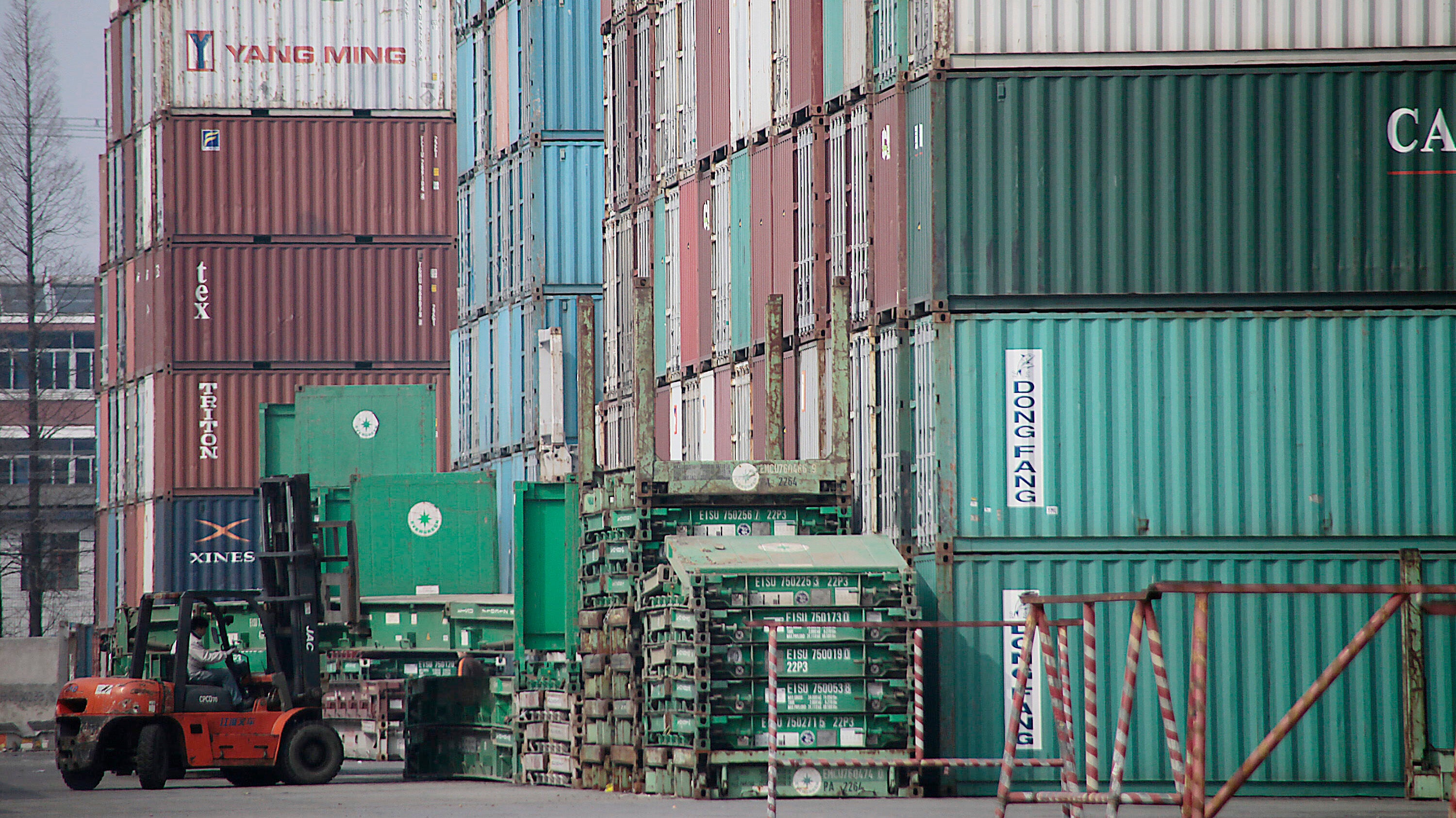 A forklift arranges the shipping containers near a port in Shangha