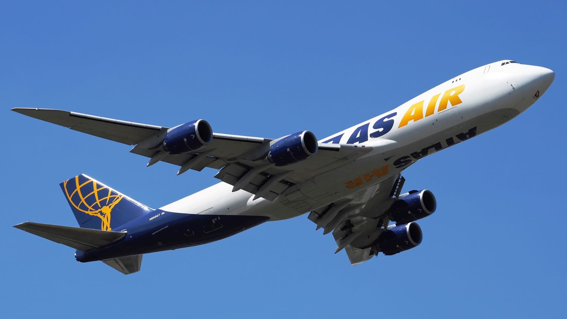 View from below of Atlas Air cargo jet with blue and gold accents.