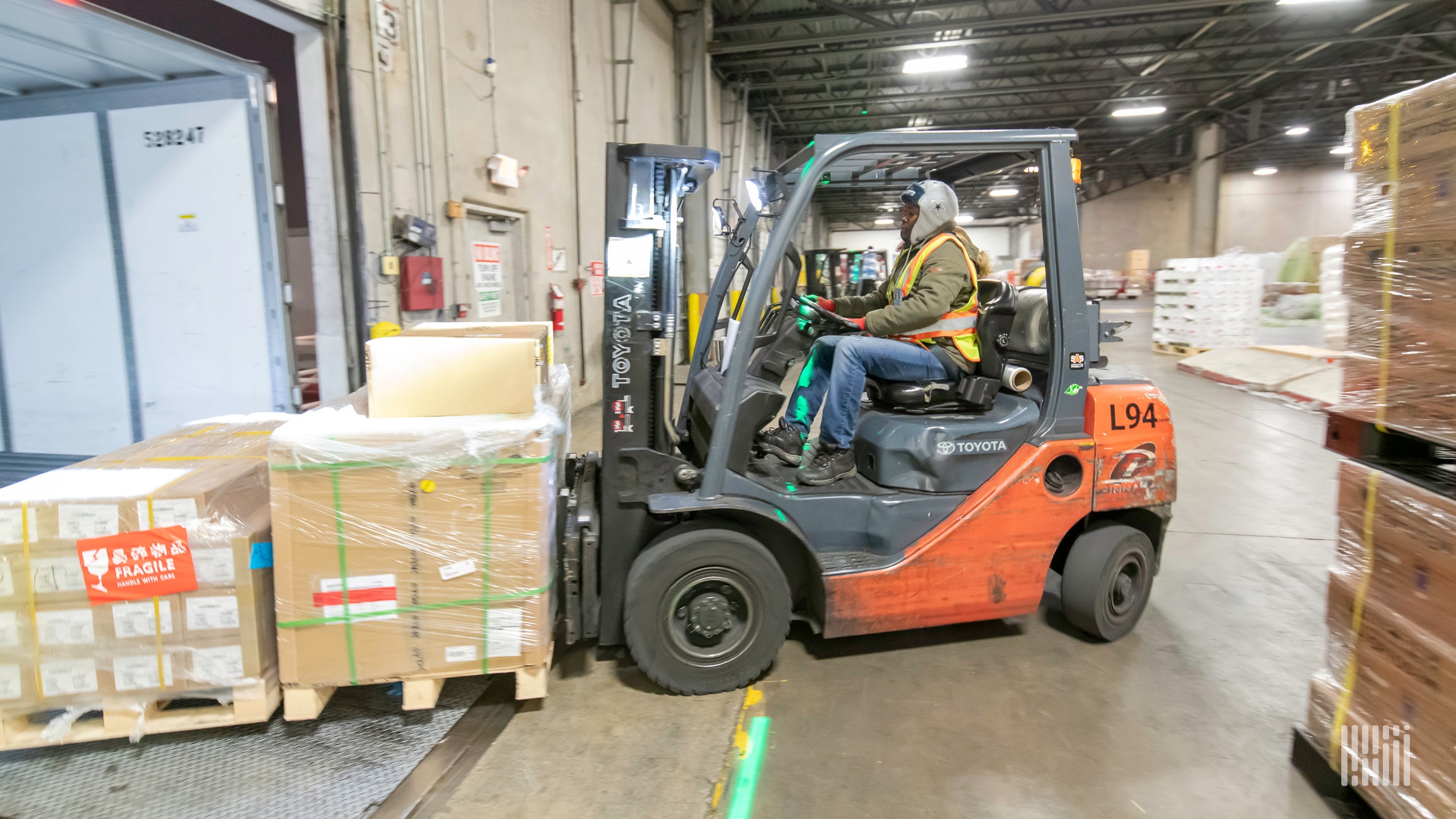 A forklift operator moving pallets into a truck