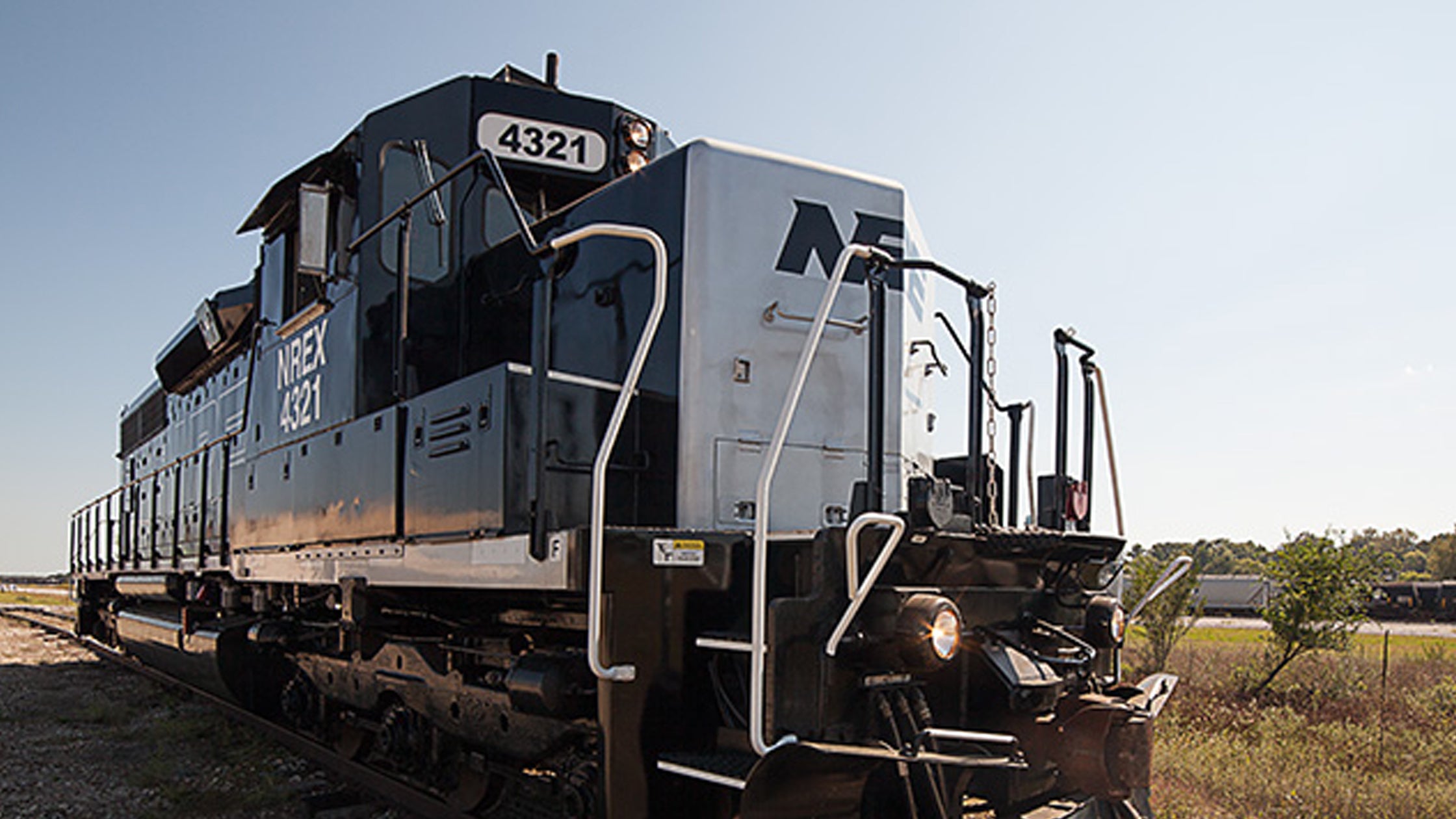 A single locomotive in a wide open field.