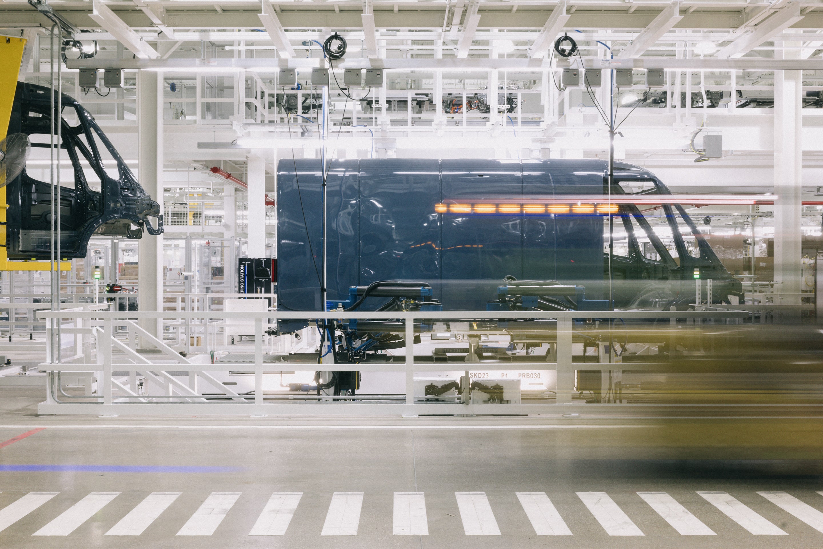 Blue Rivian van on assembly line