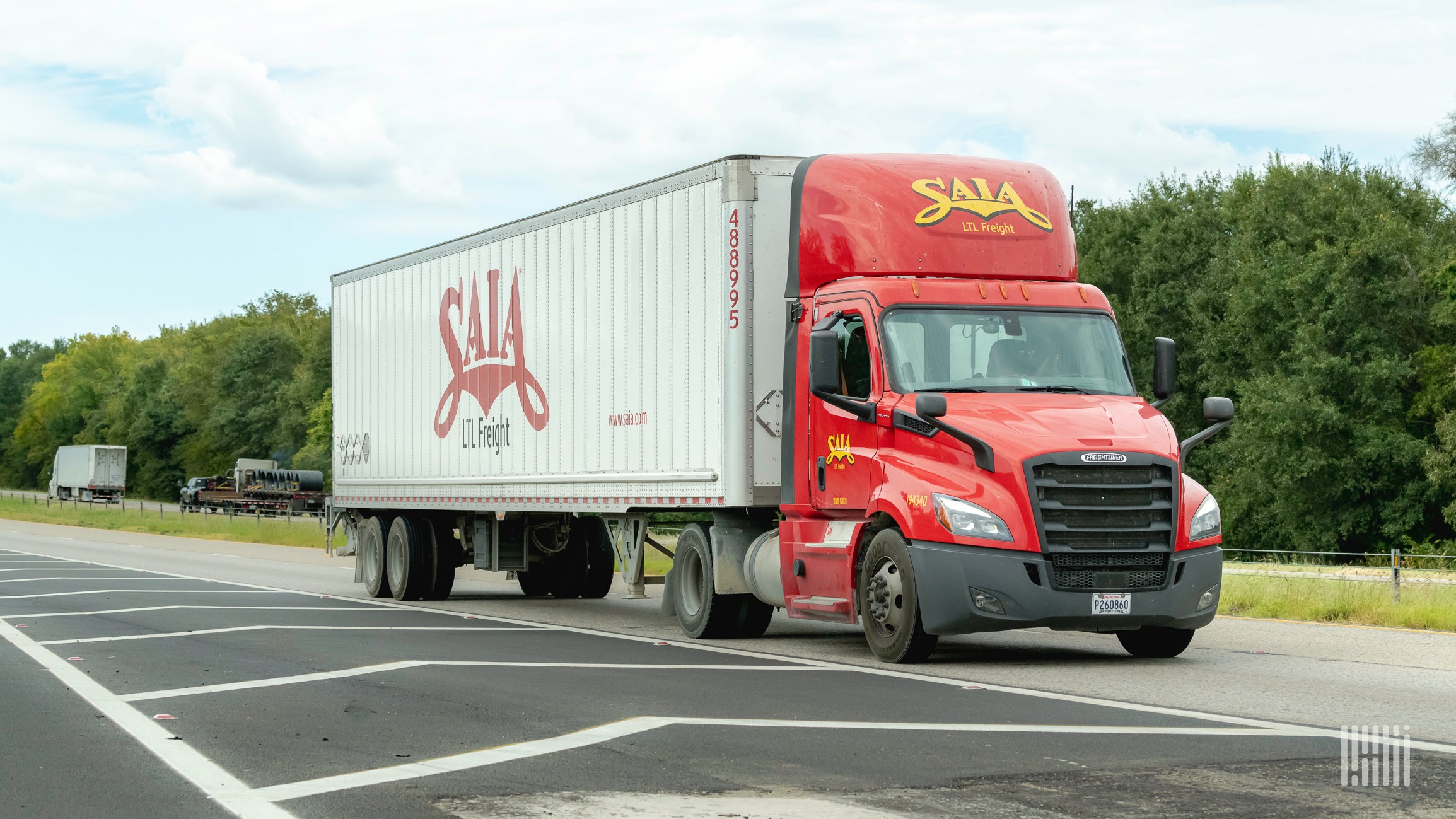 A red Saia truck and white trailer on highway