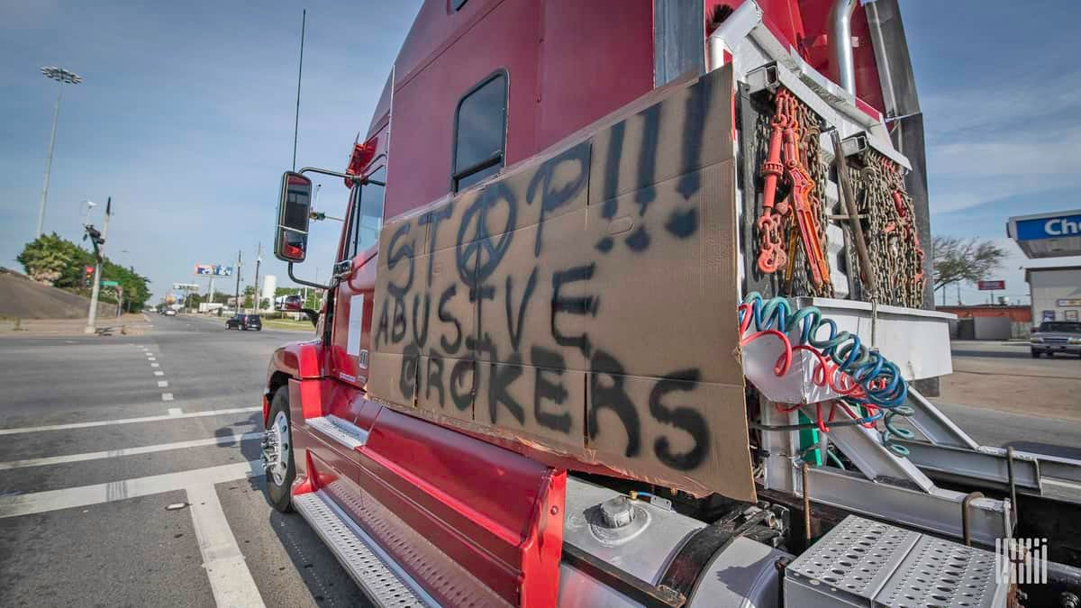 Truck with sign protesting abusive brokers.