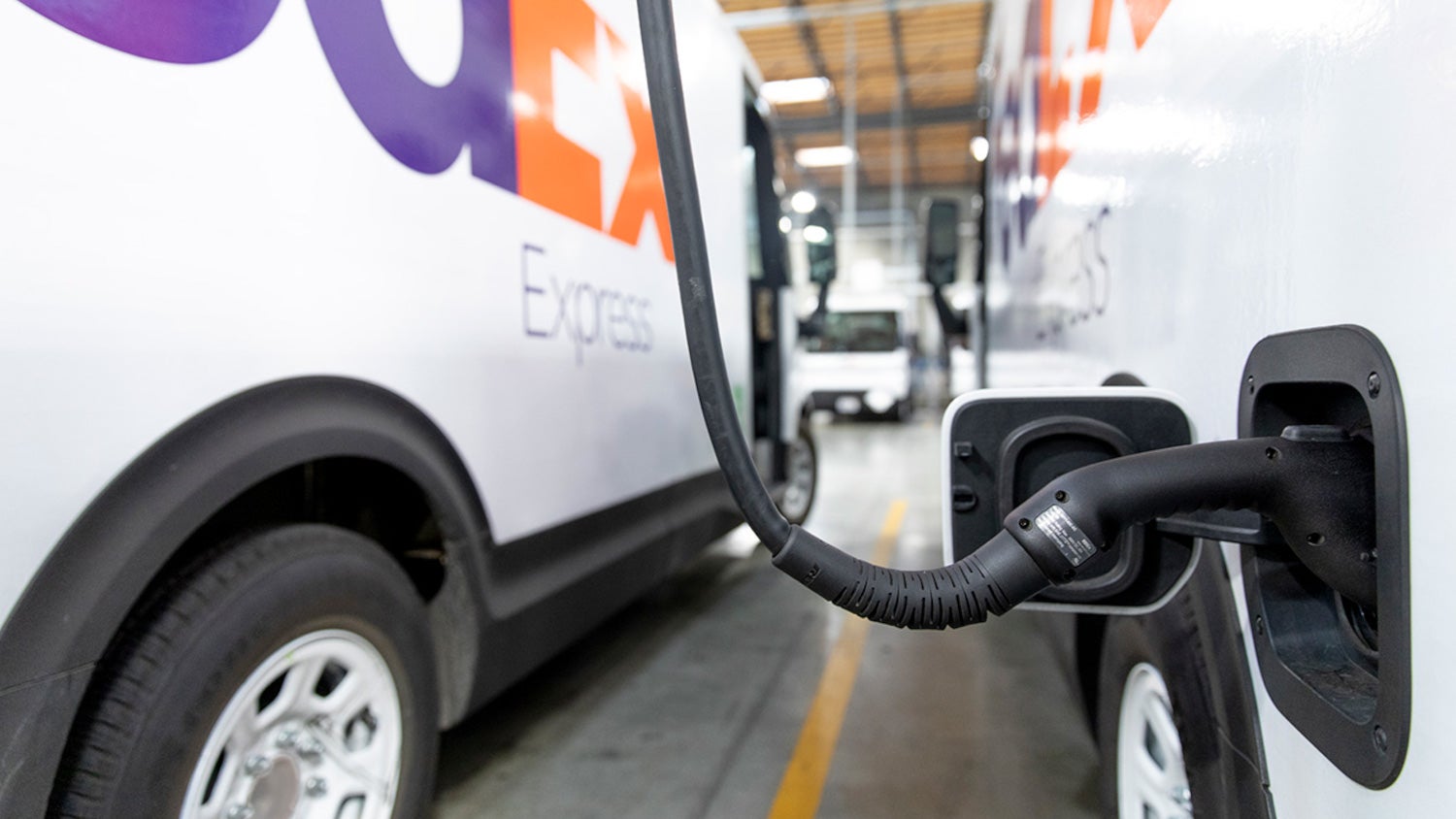 View of FedEx electric van plugged into charging unit